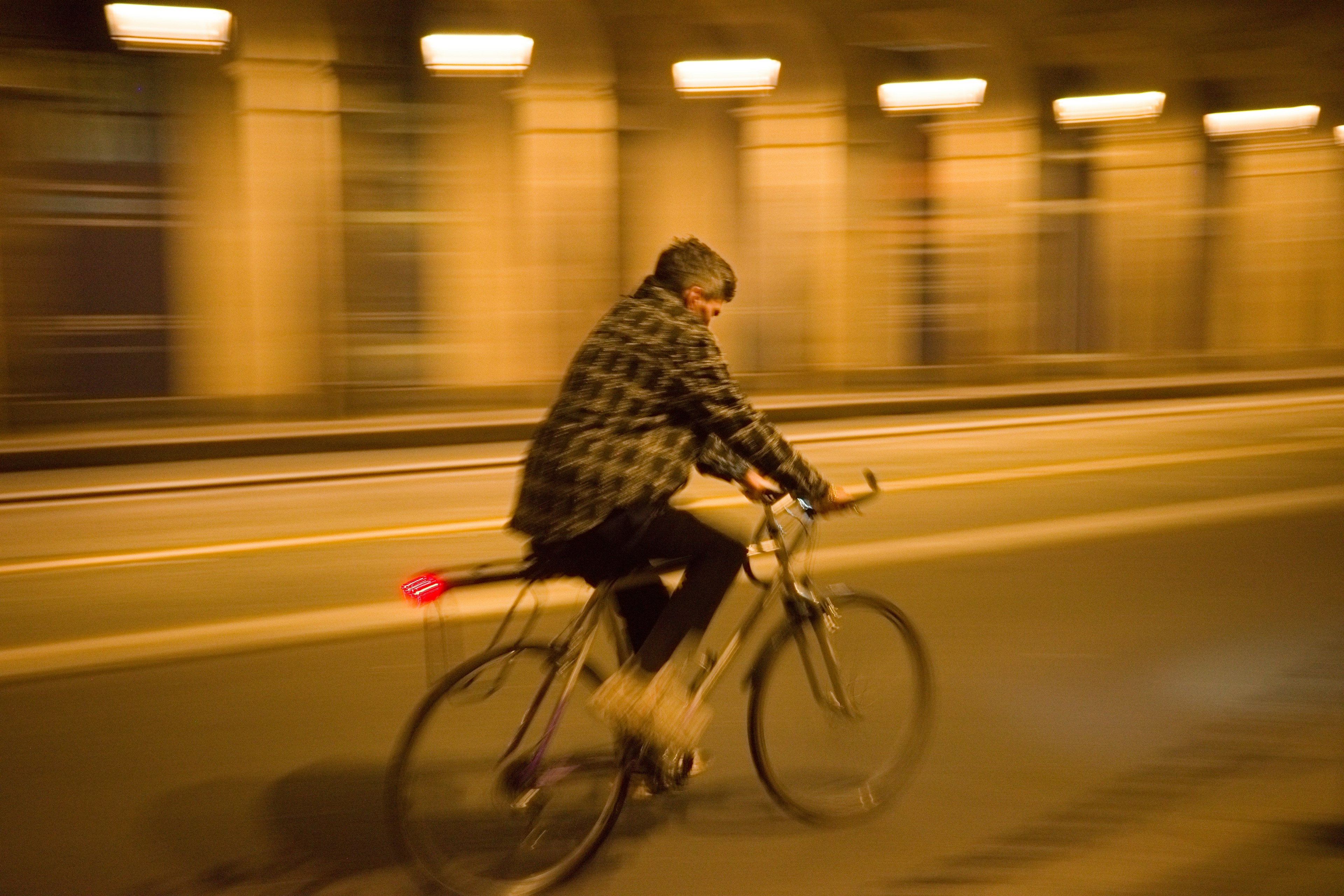 A person riding a bicycle in a tunnel at night with motion blur