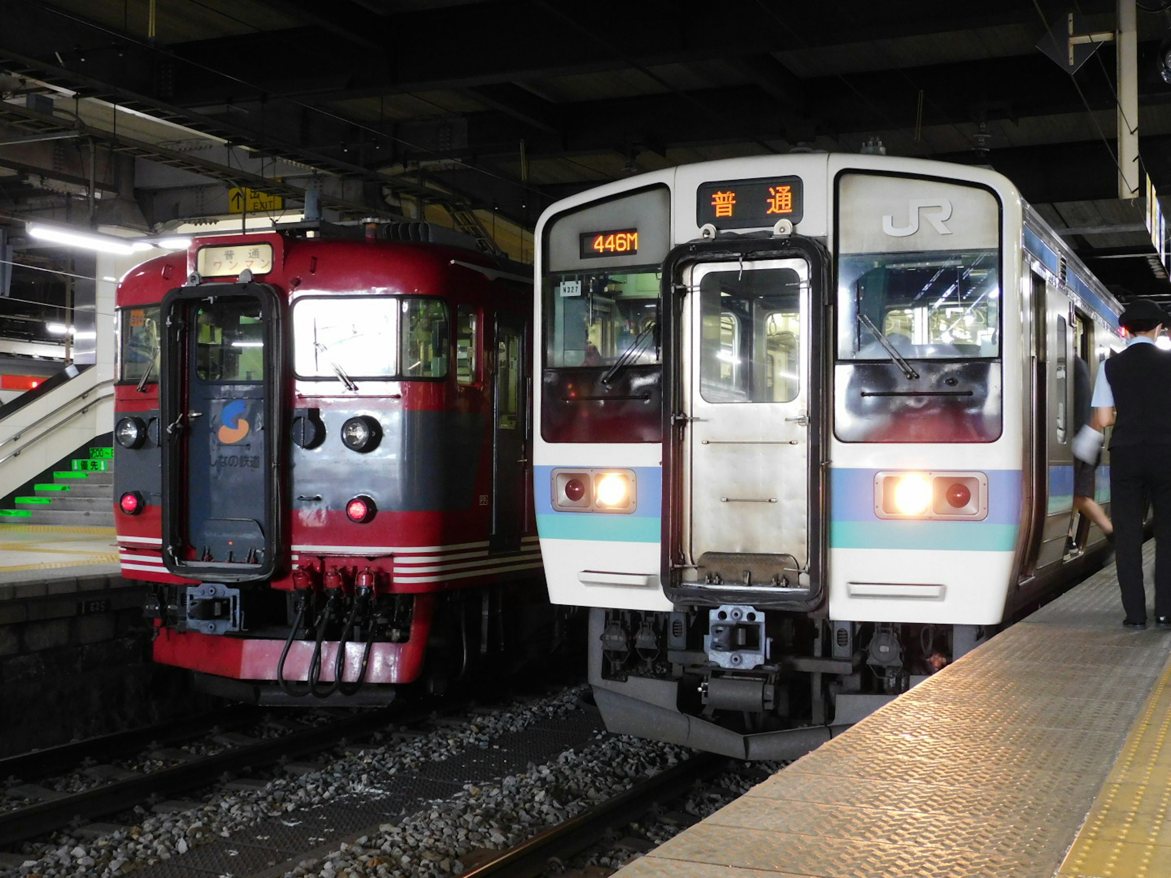 Red and white trains side by side at a station