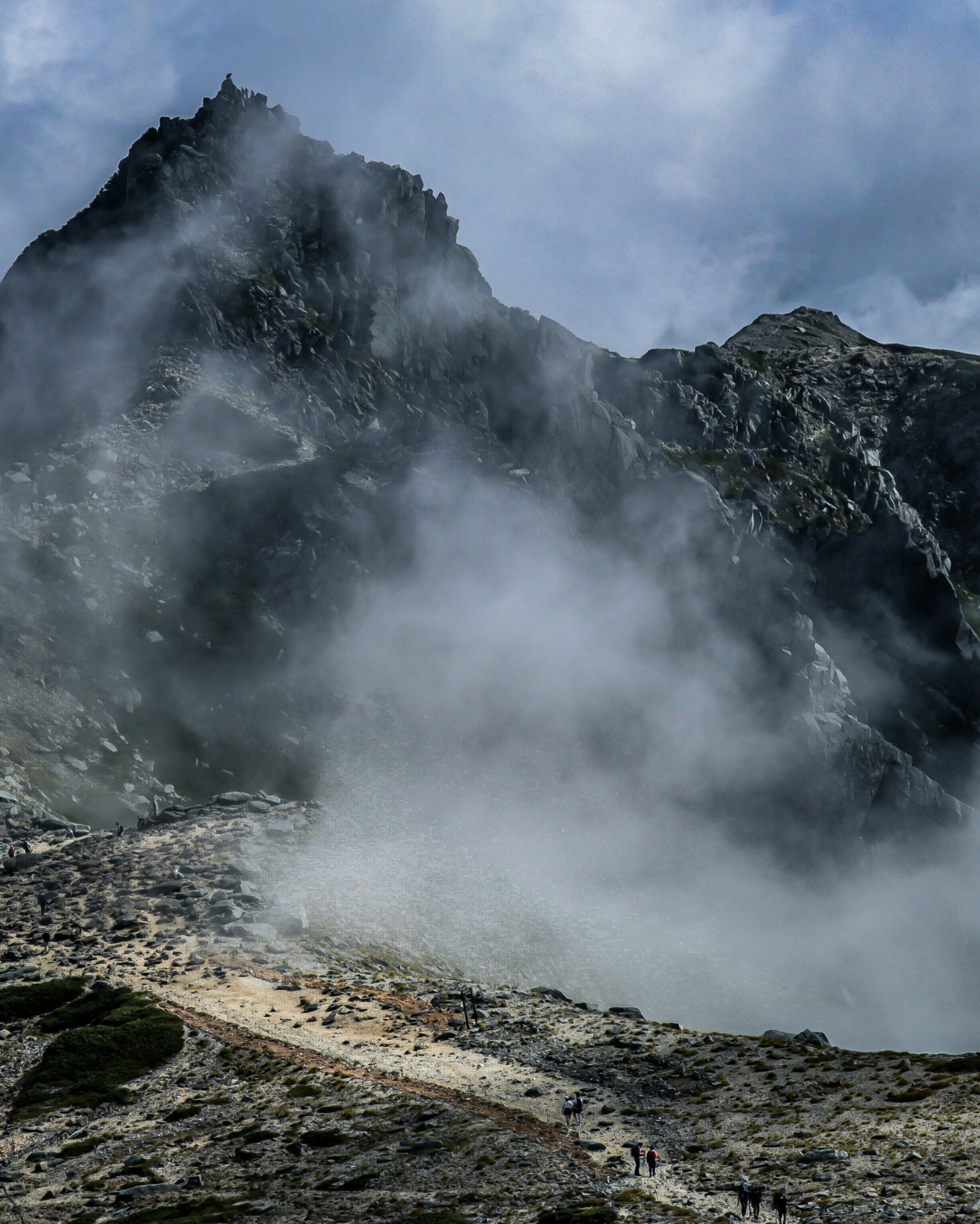 Paesaggio montano avvolto nella nebbia Alta cima che emerge dalle nuvole