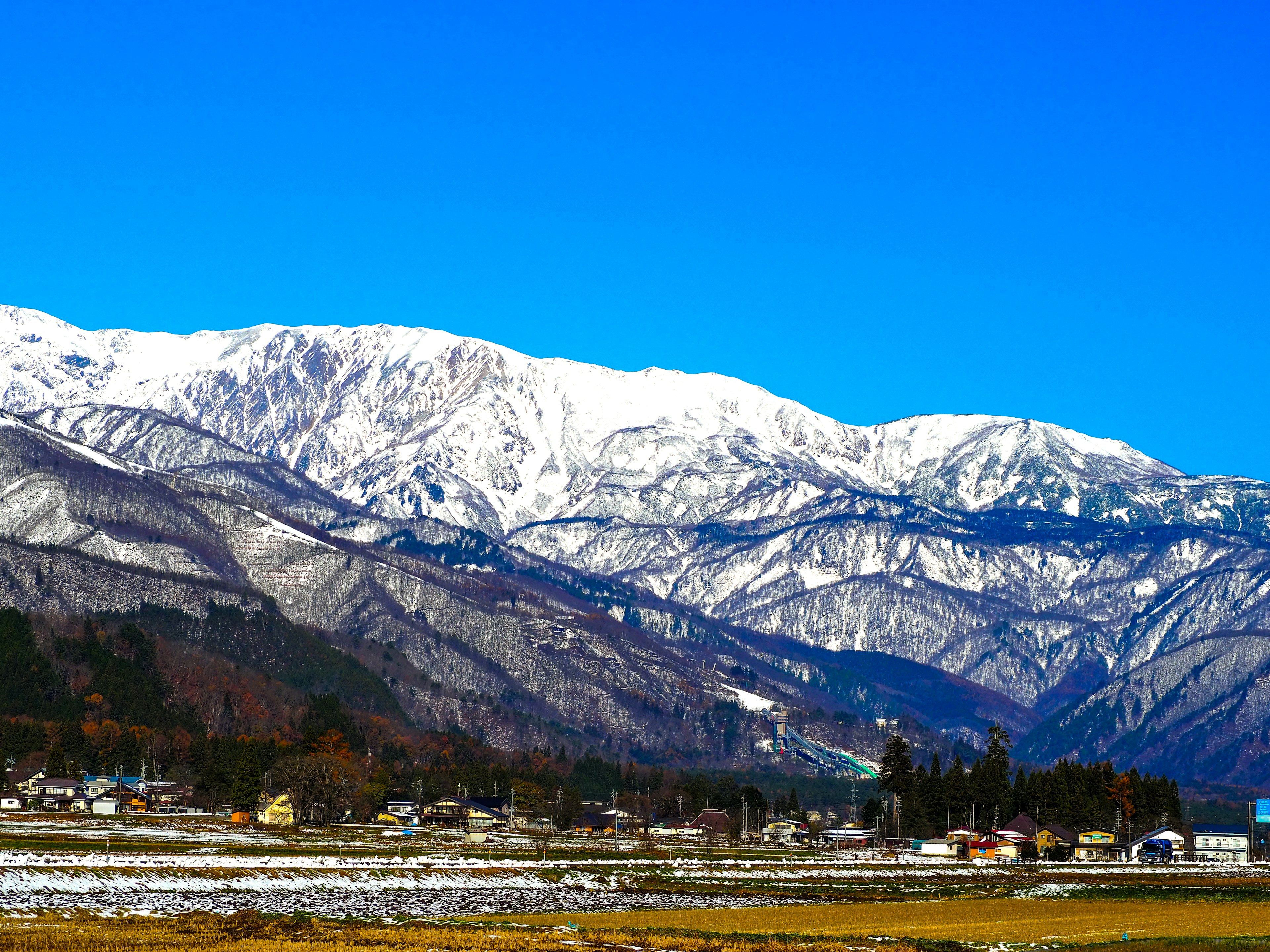 雪に覆われた山々と青い空の美しい風景