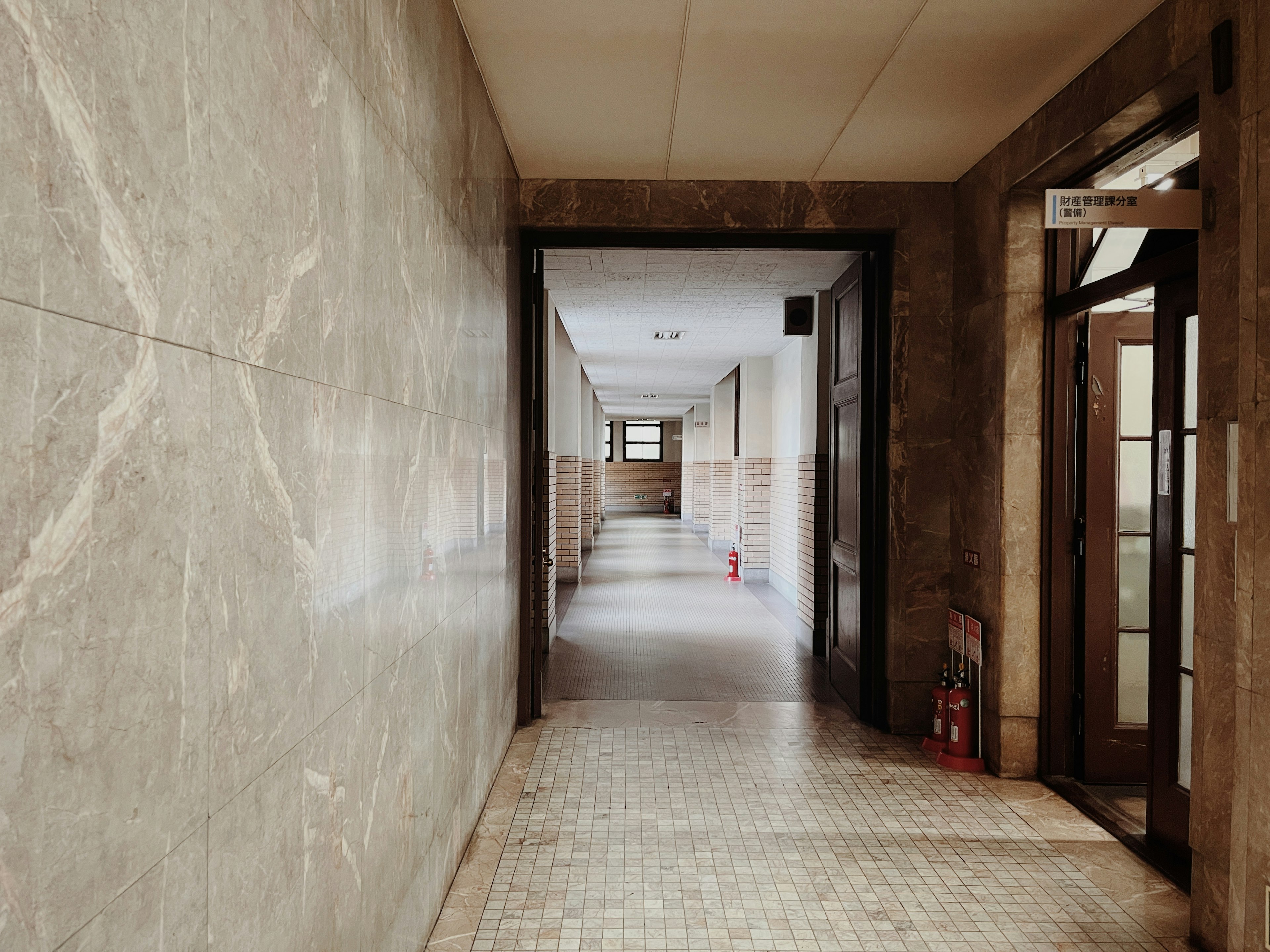 Long corridor with wooden doors and marble walls