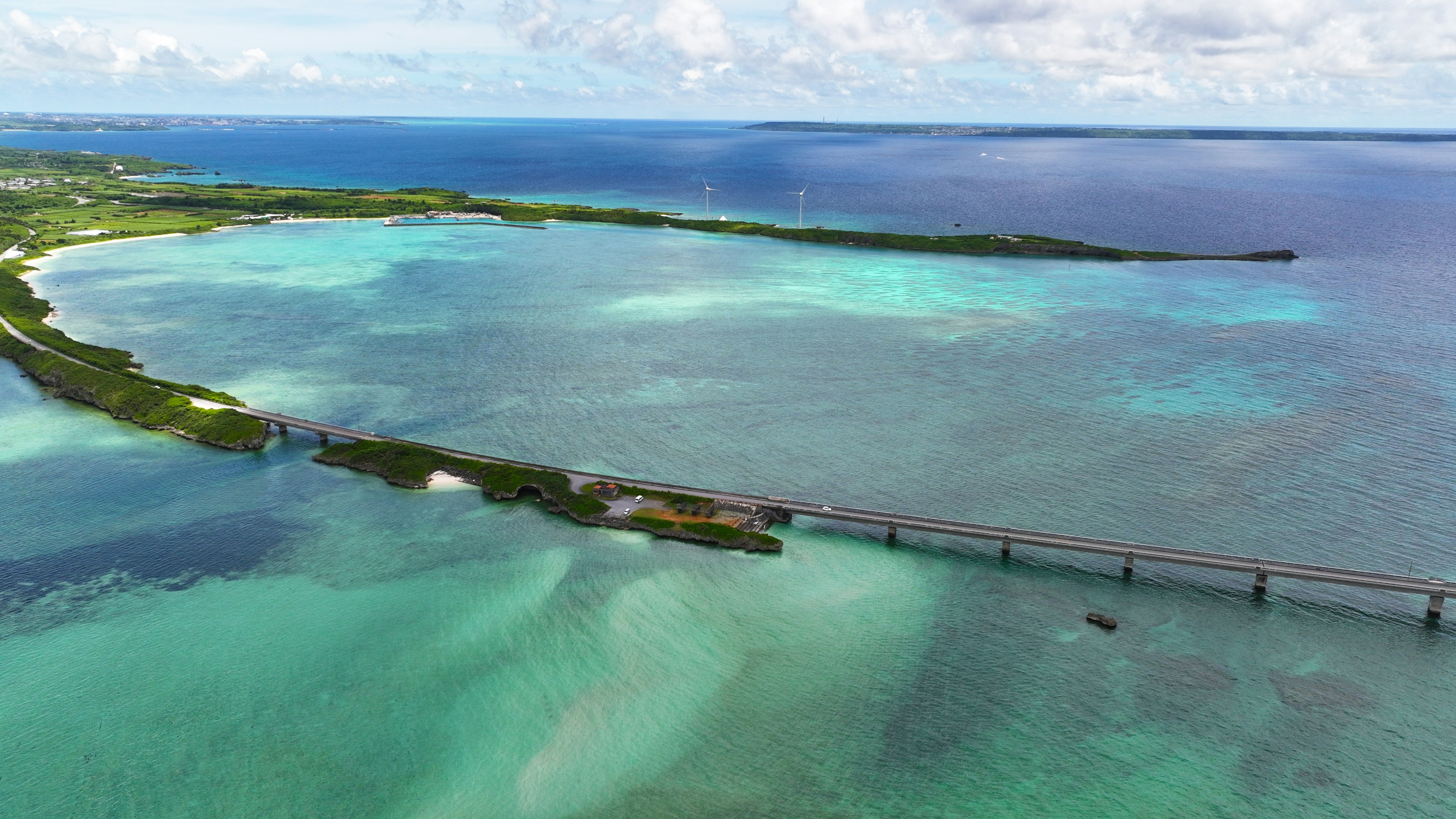 Luftaufnahme von atemberaubendem blauen Wasser und grünen Inseln mit einer langen Brücke über der Oberfläche