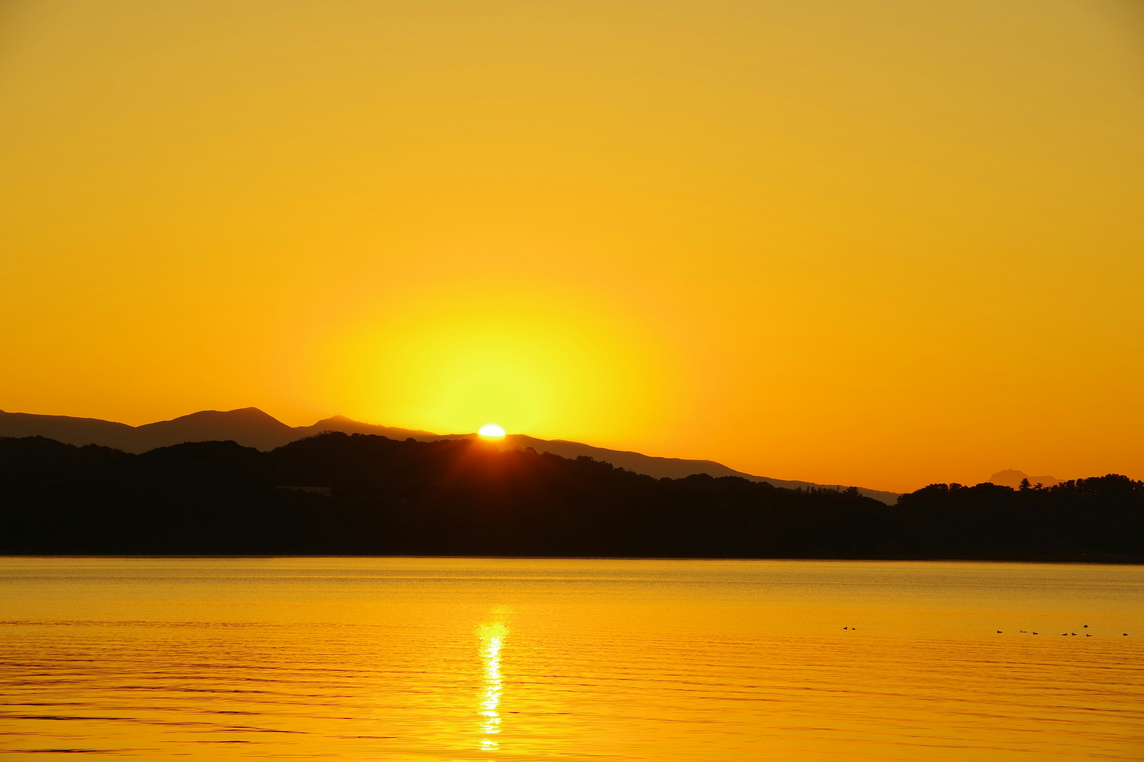 Schöner Sonnenuntergang, der zwischen den Bergen aufgeht