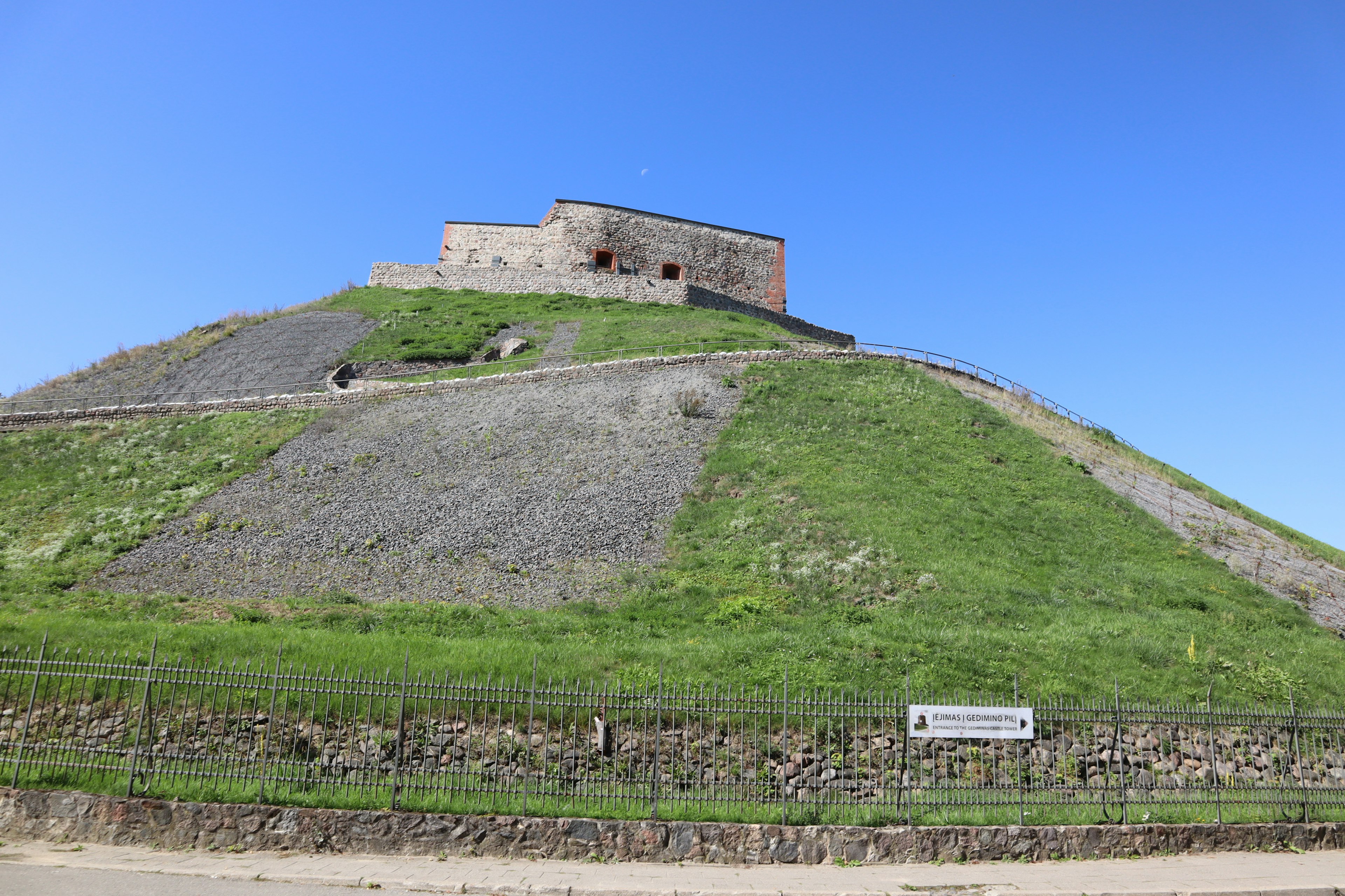 Structure ancienne sur une colline verte sous un ciel bleu