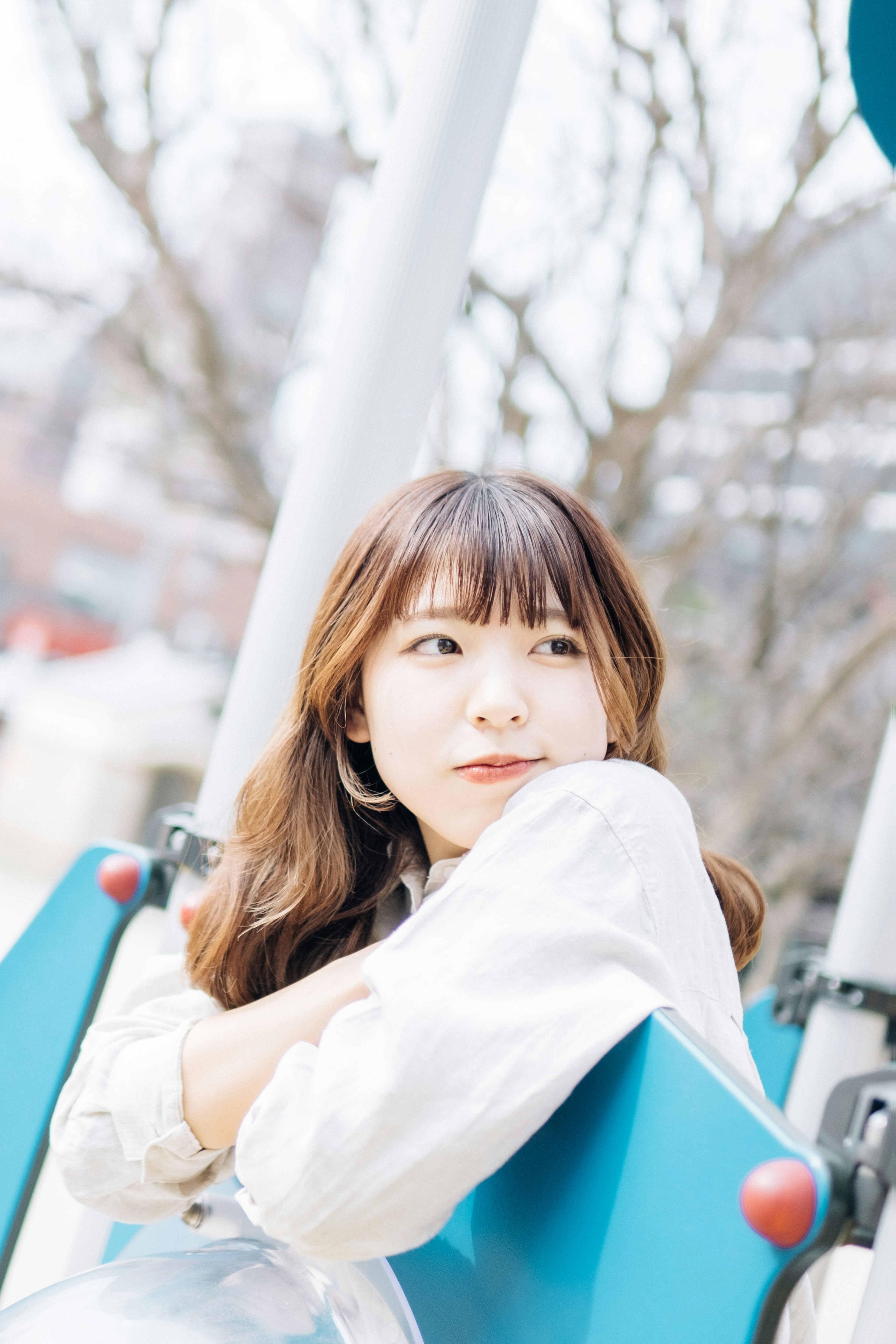 Portrait of a woman sitting on a swing in a park