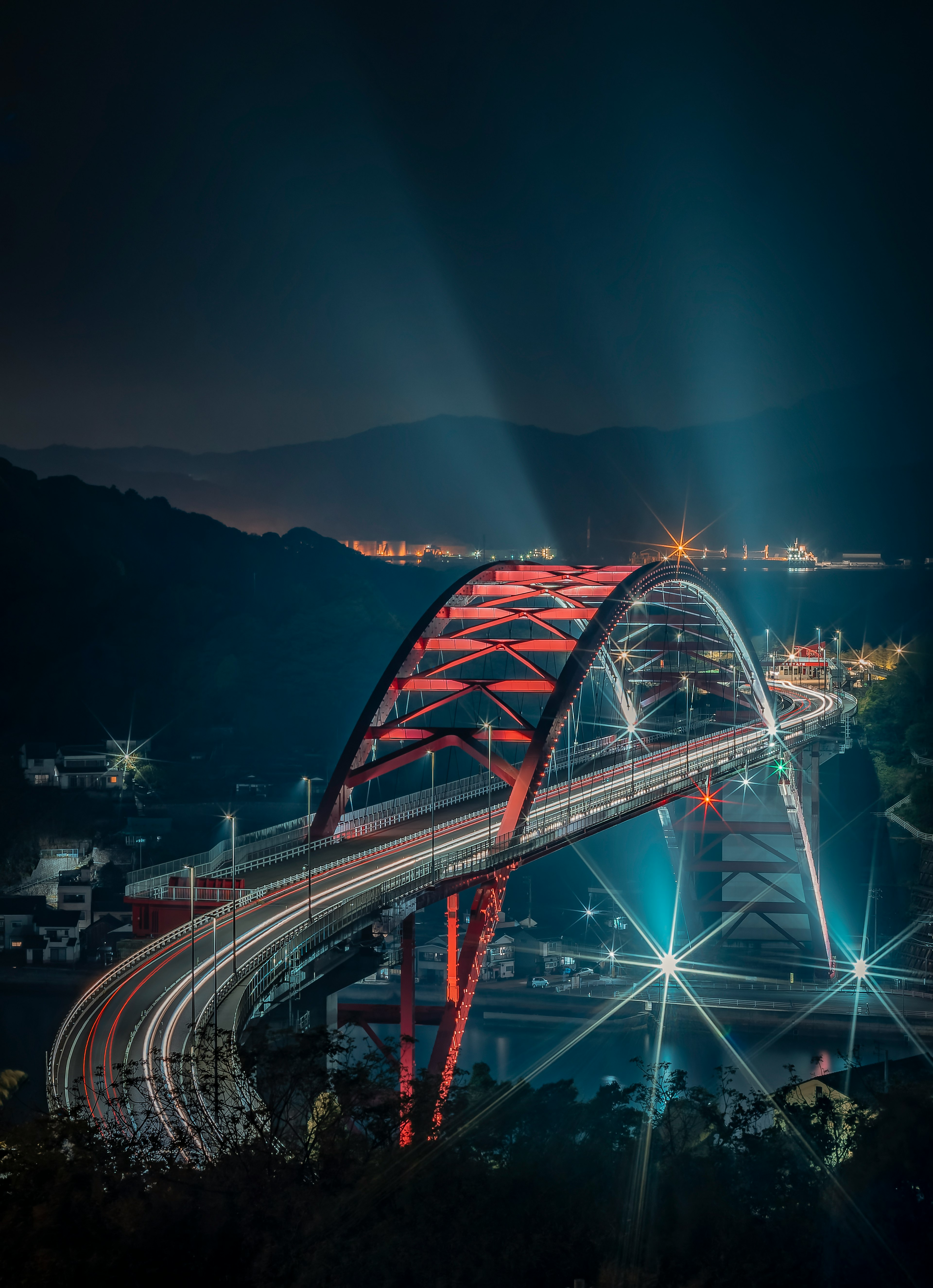 Beautifully lit arch bridge at night with flowing traffic