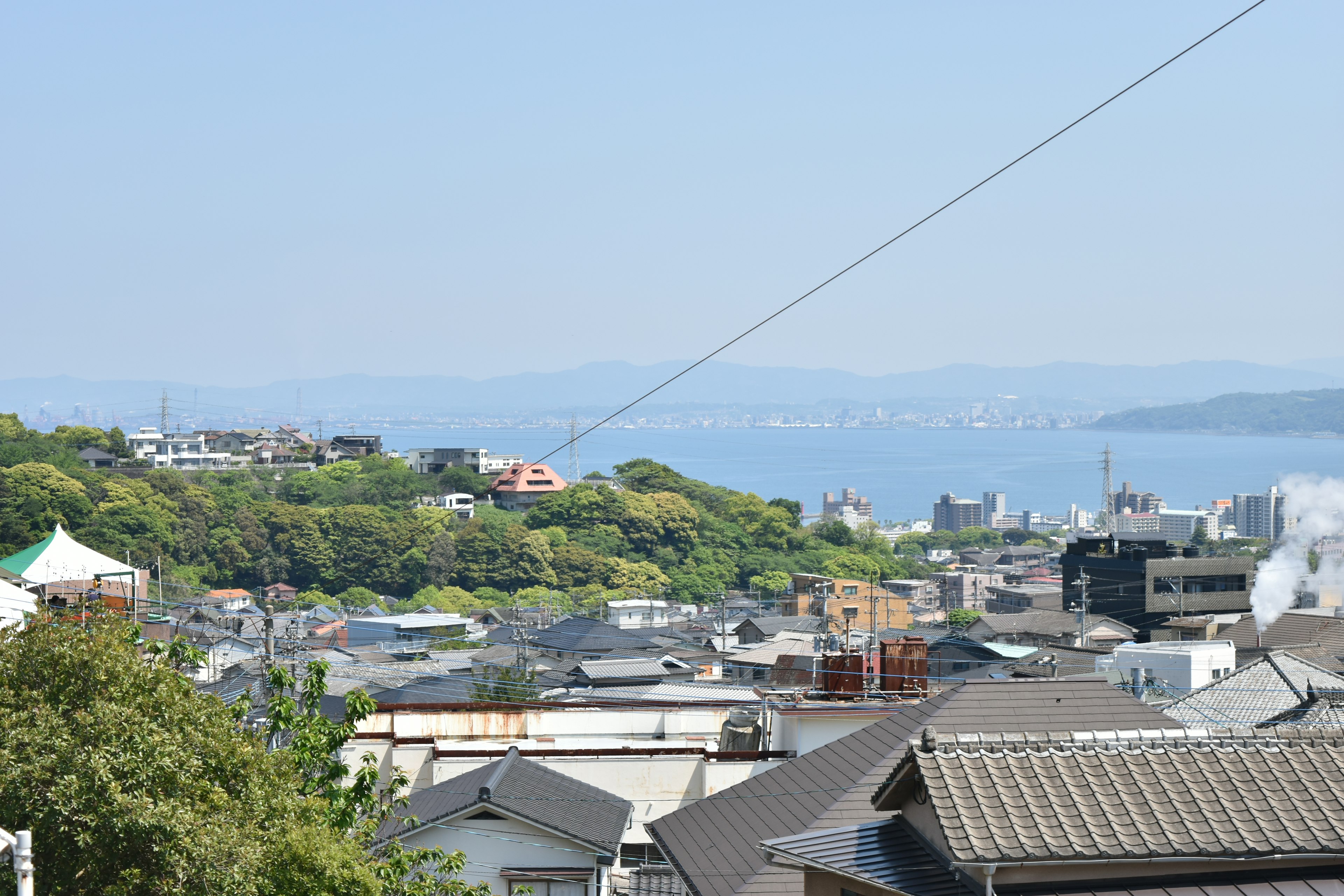 城市風景，藍色海洋和綠色山丘