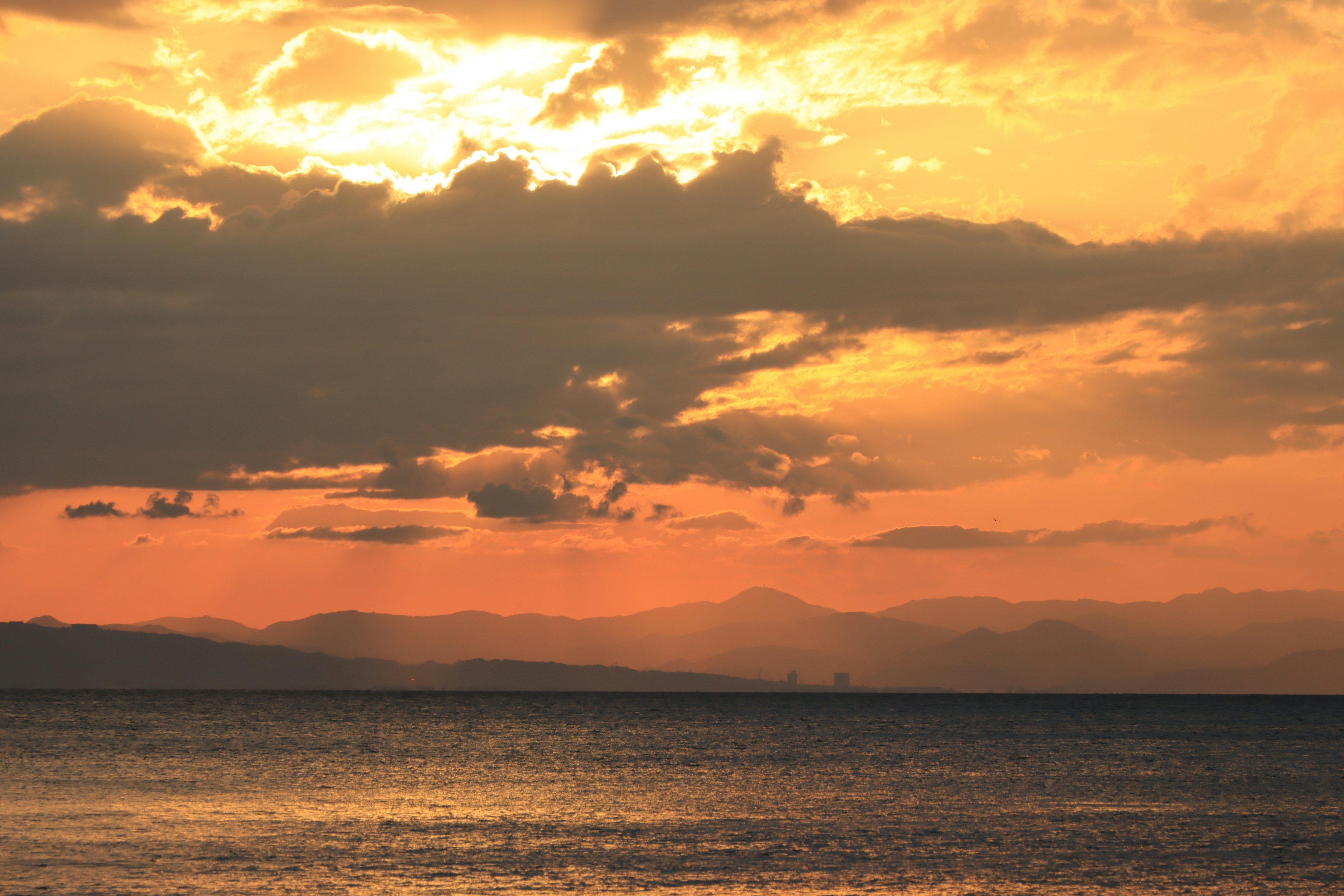 海上日落和远处山脉的景色