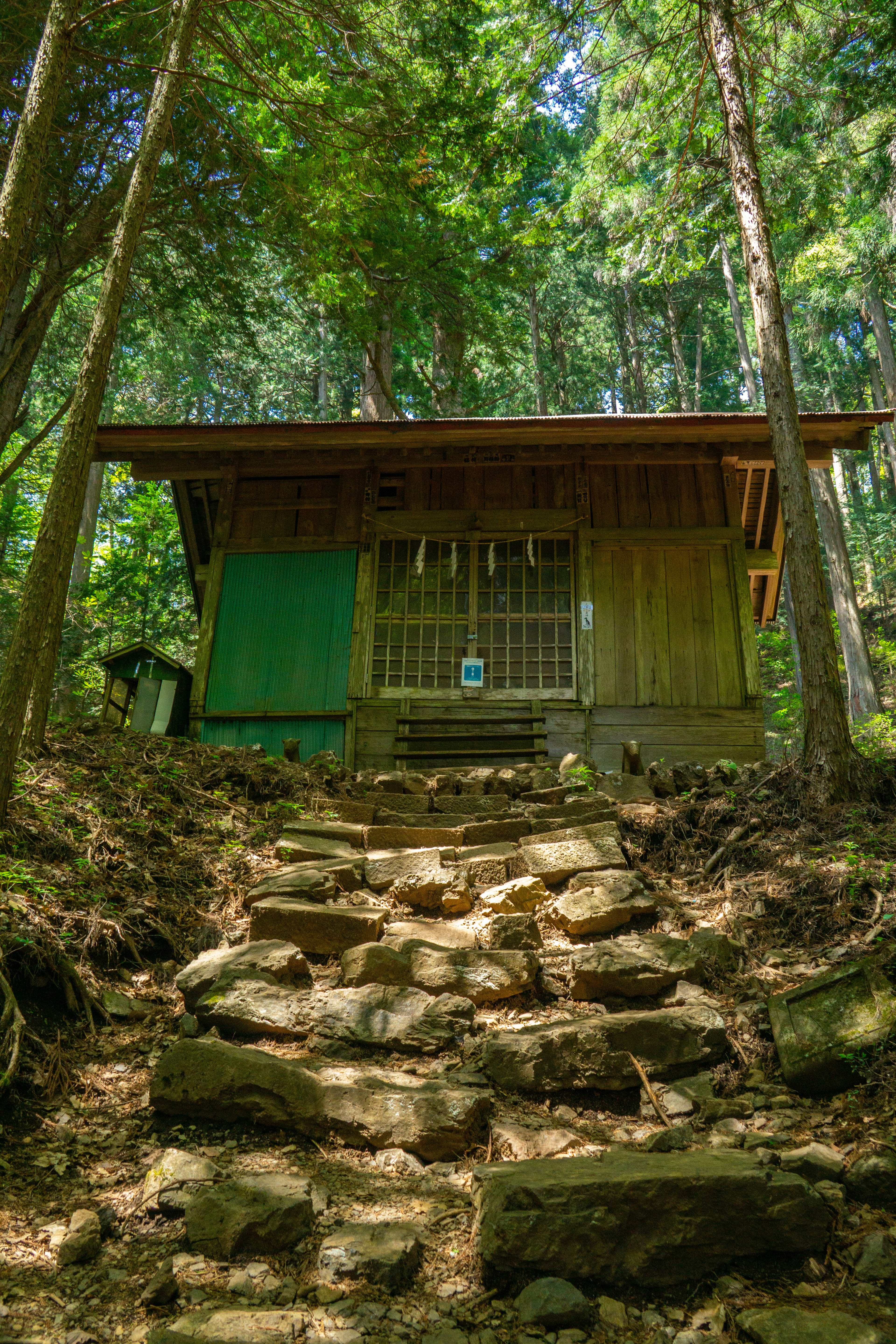 森の中にある小さな木造の建物と石の階段