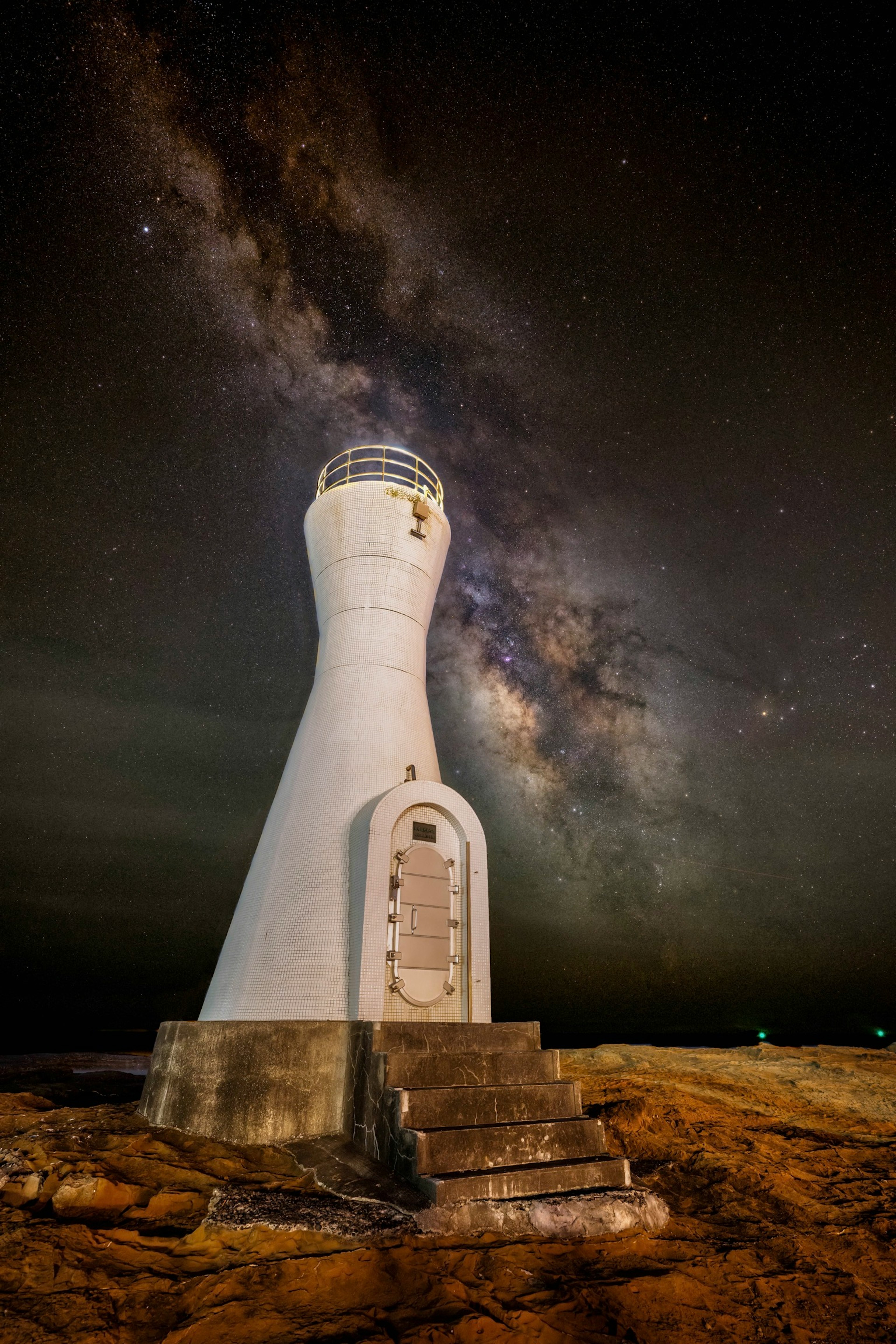 星空の下に立つ灯台の美しい夜景