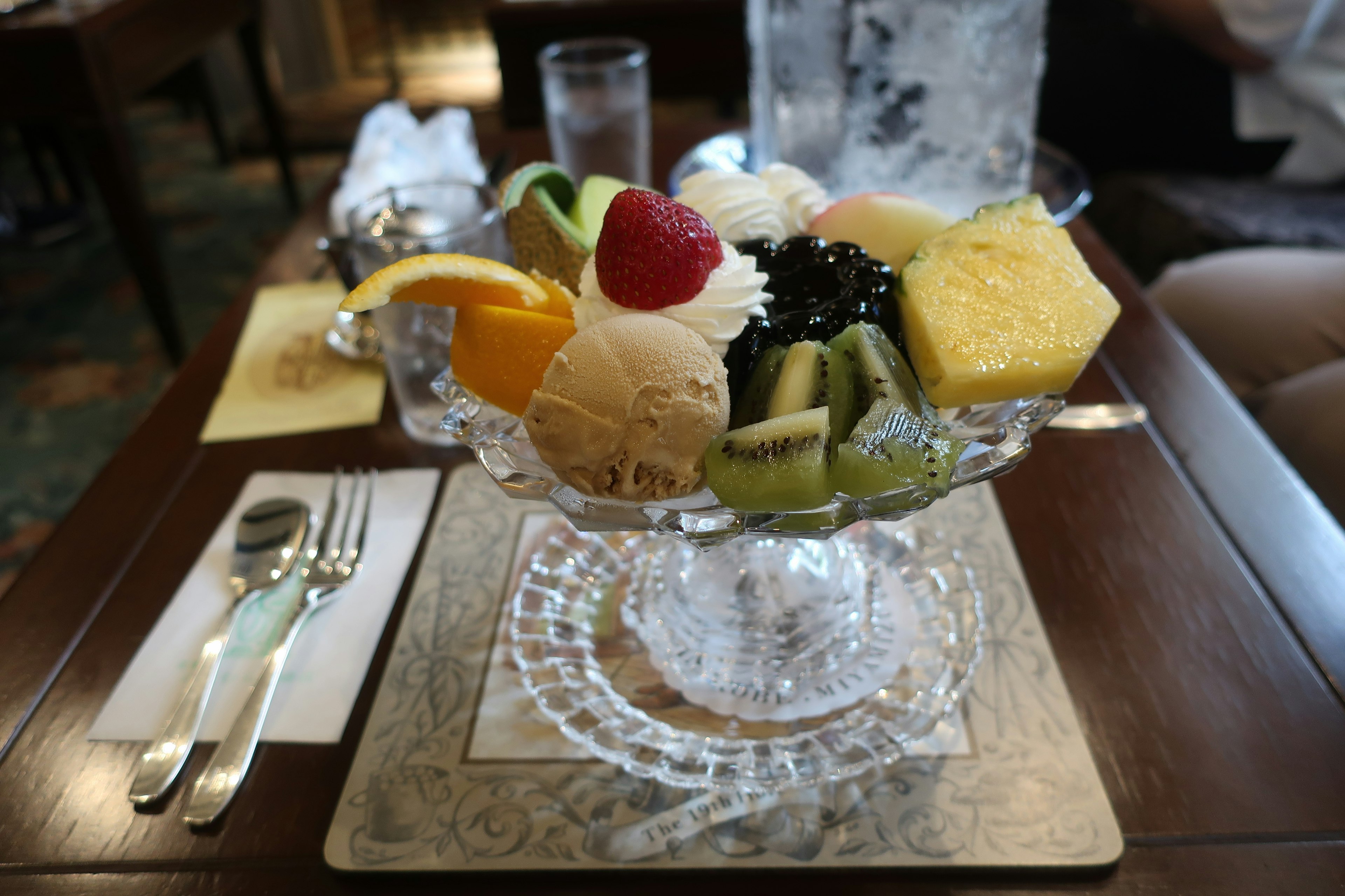 Tazón de cristal lleno de frutas variadas y helado