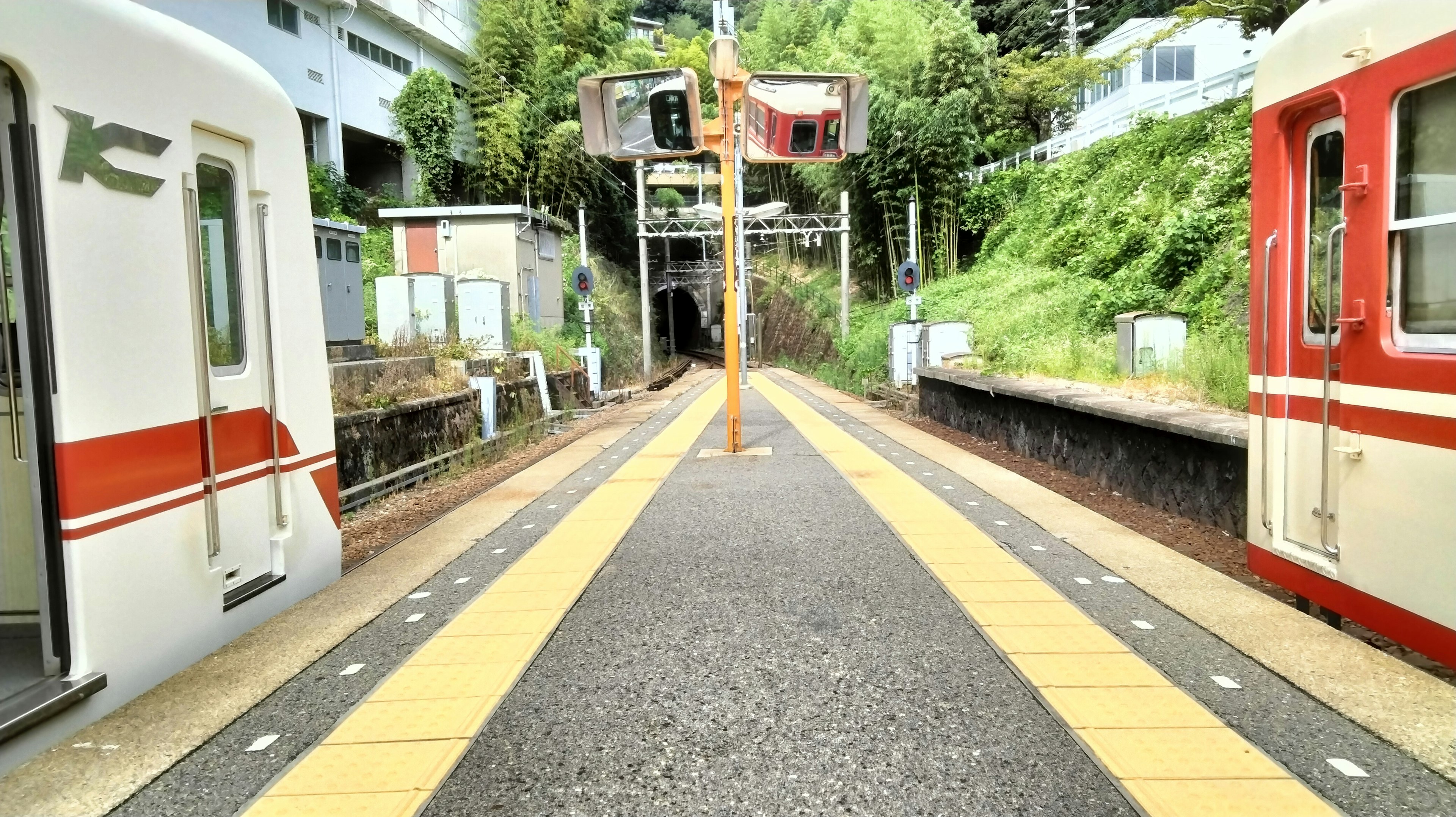 赤と白の電車が停車している駅のプラットフォーム