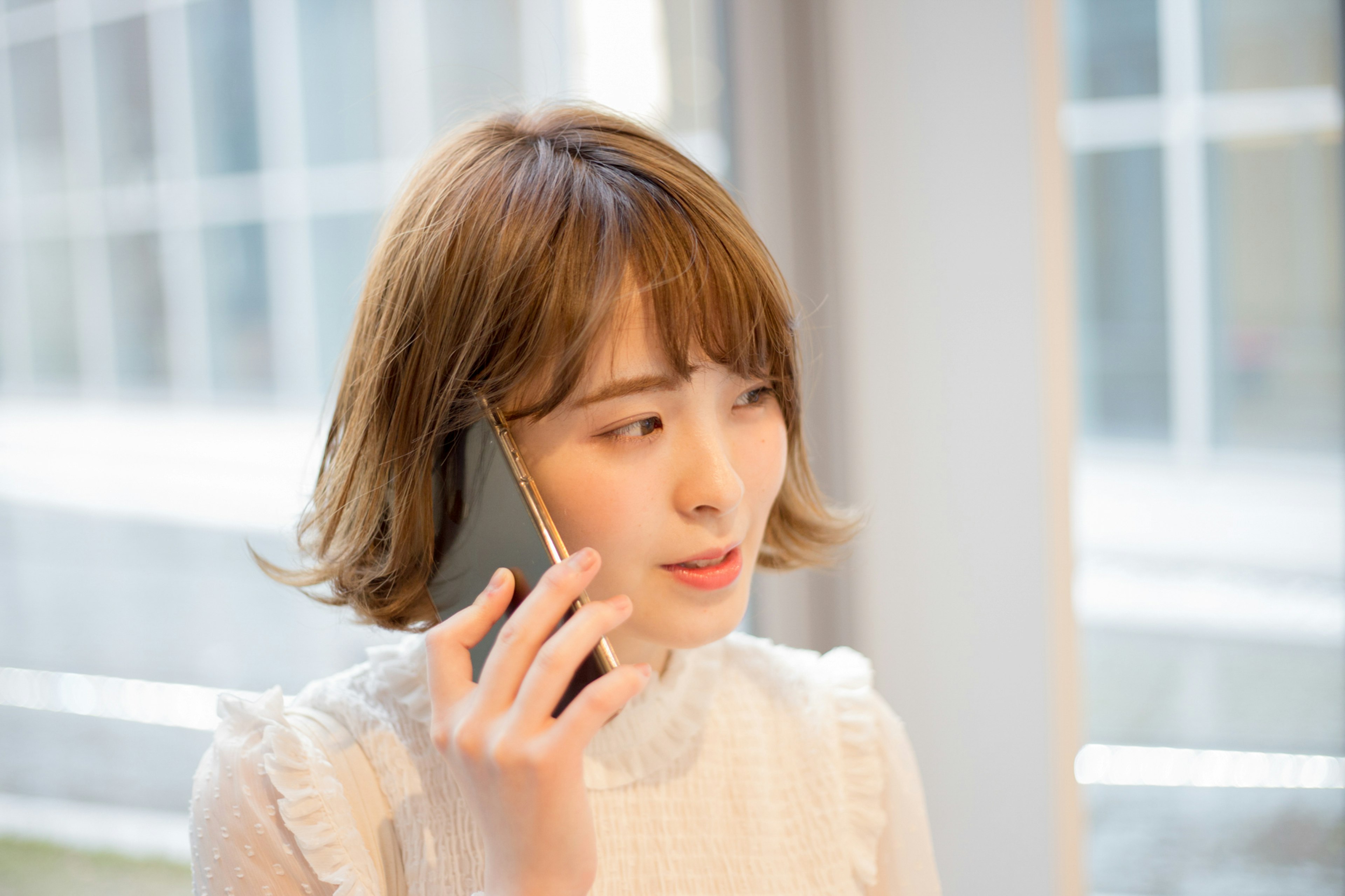 Portrait of a woman talking on the phone Natural light from a window