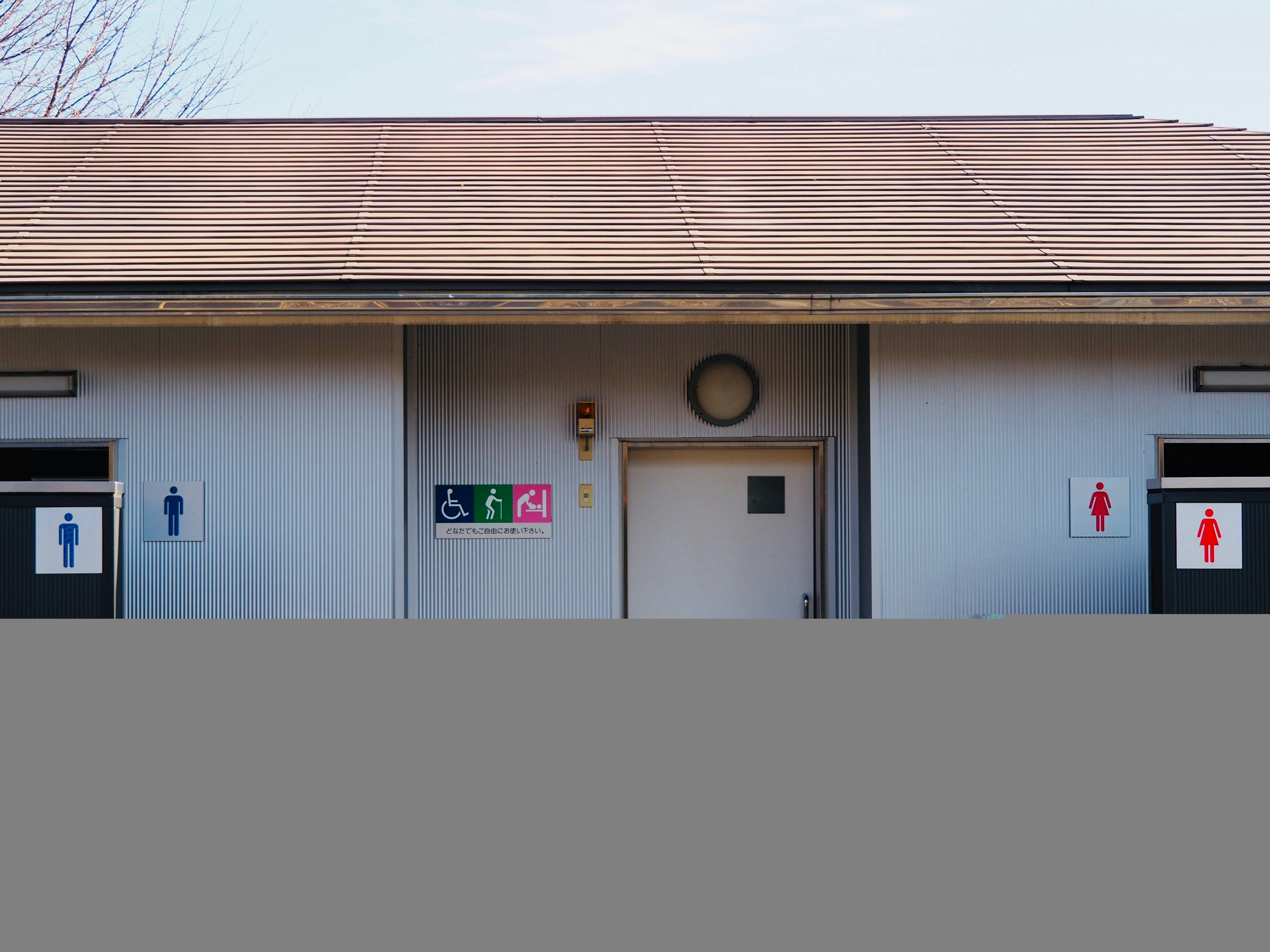 Extérieur d'un bâtiment avec des panneaux de toilettes pour hommes et femmes visibles