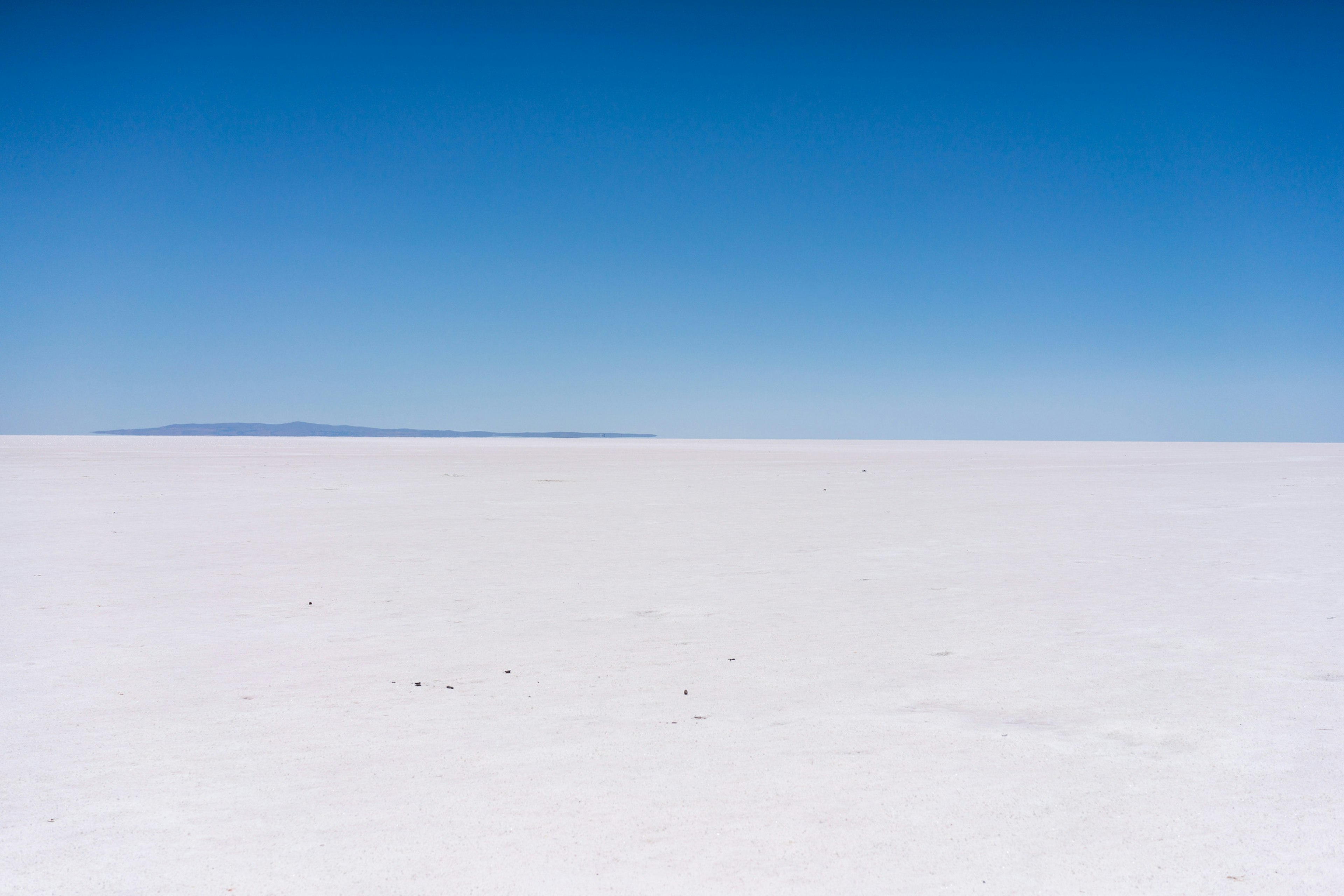 Vaste plaine de sel blanche sous un ciel bleu clair