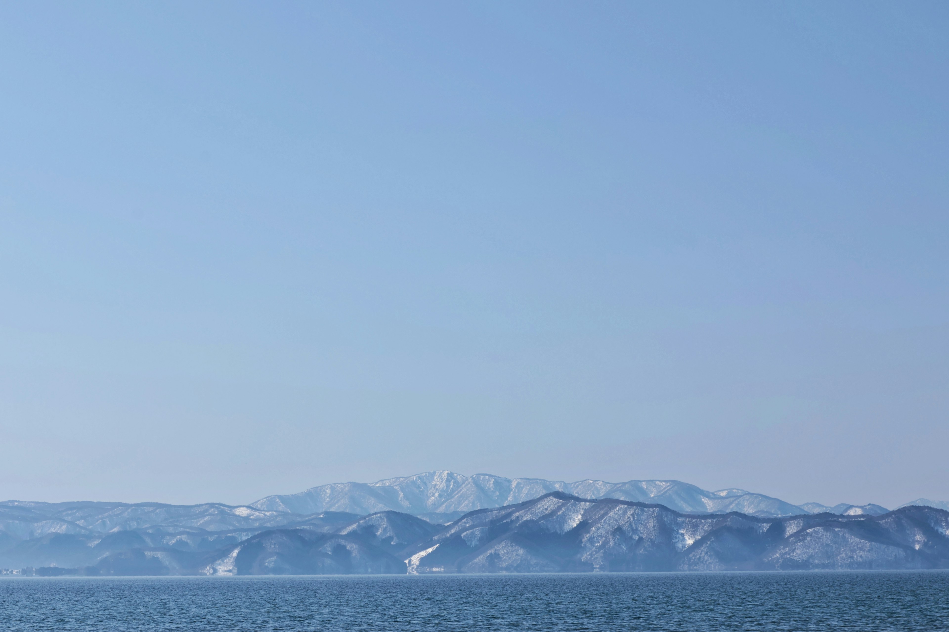 Snow-covered mountains against a clear blue sky