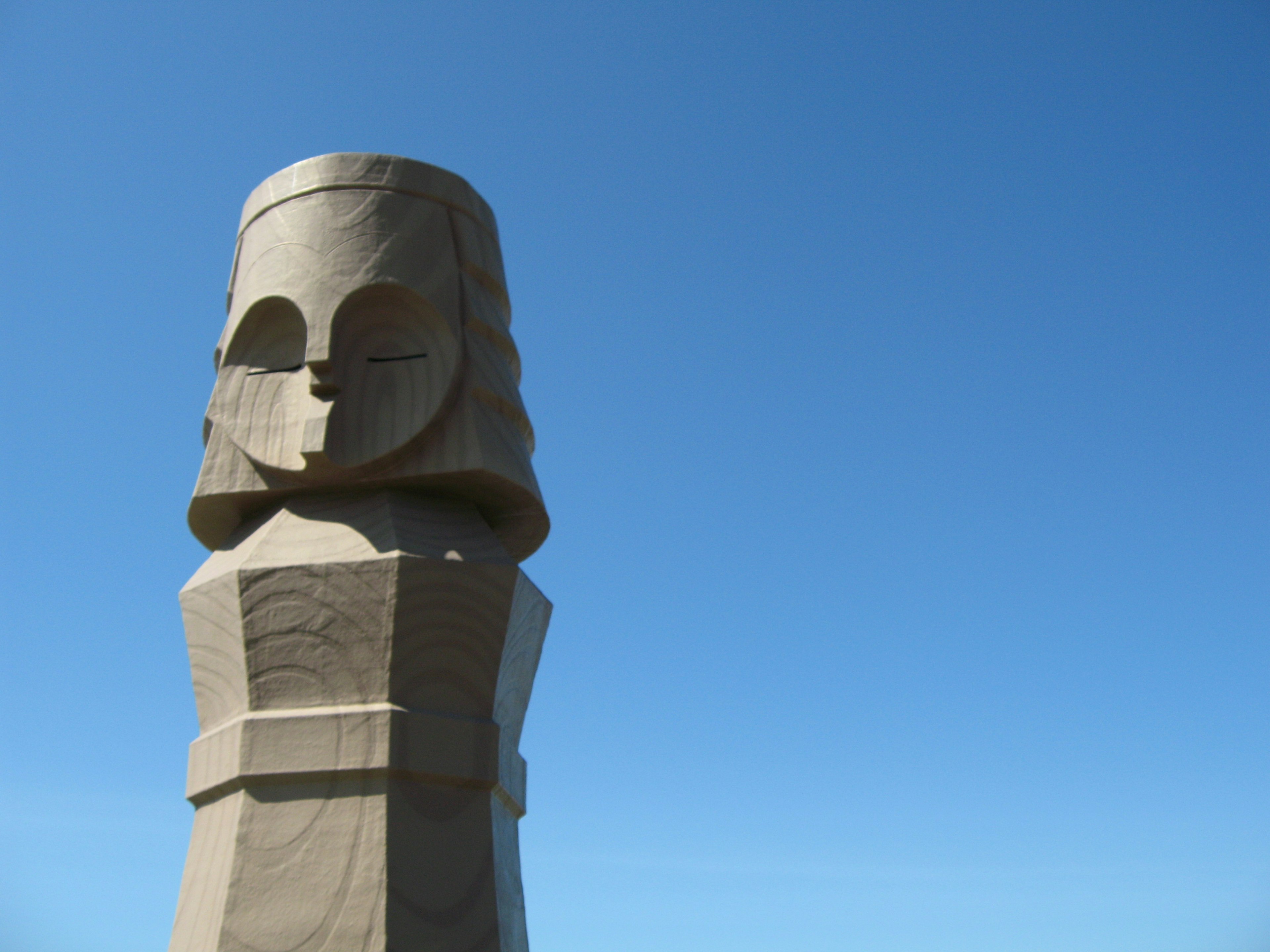 Escultura Moai de pie bajo un cielo azul