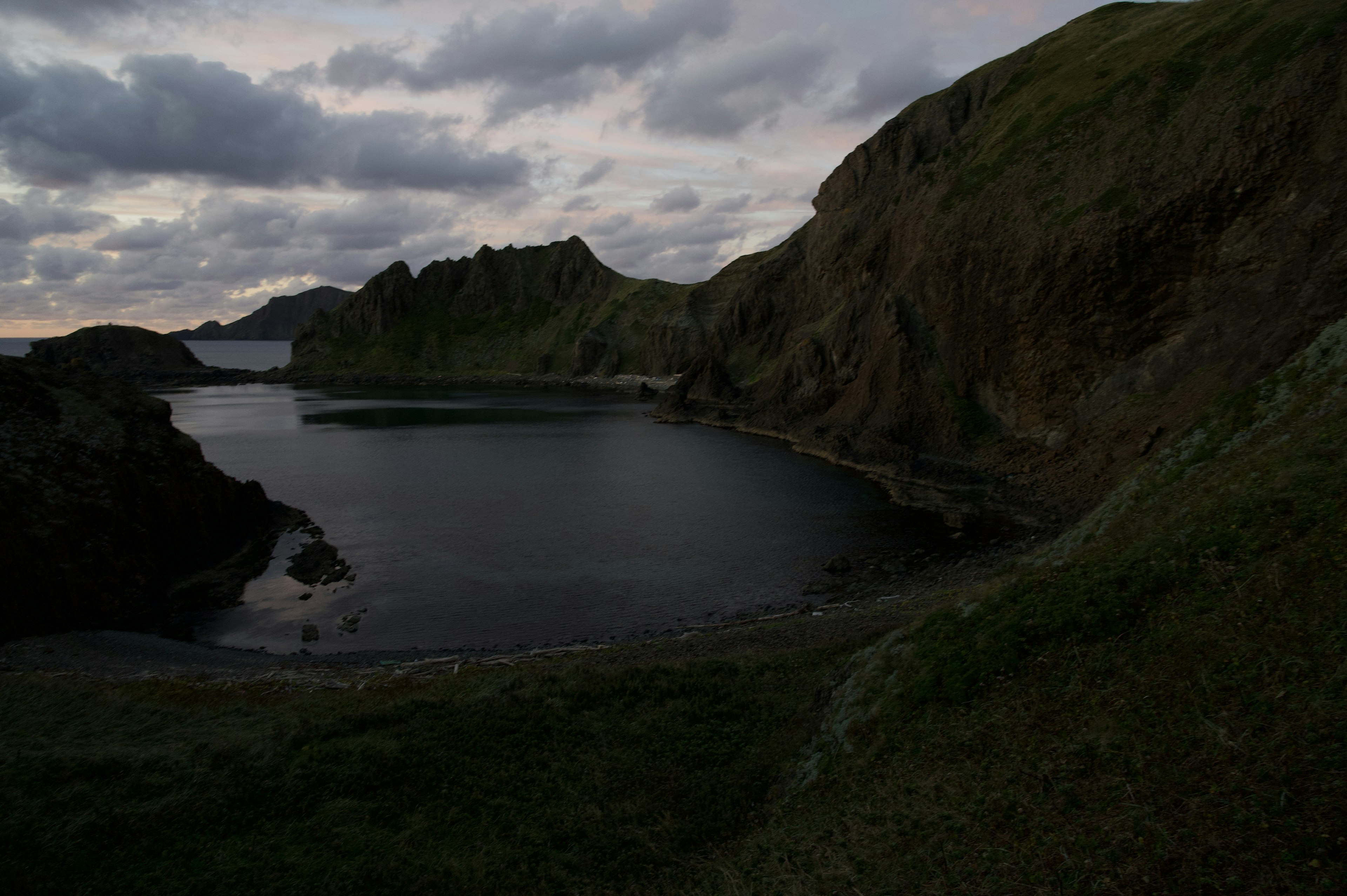 Dark coastal landscape with a calm bay