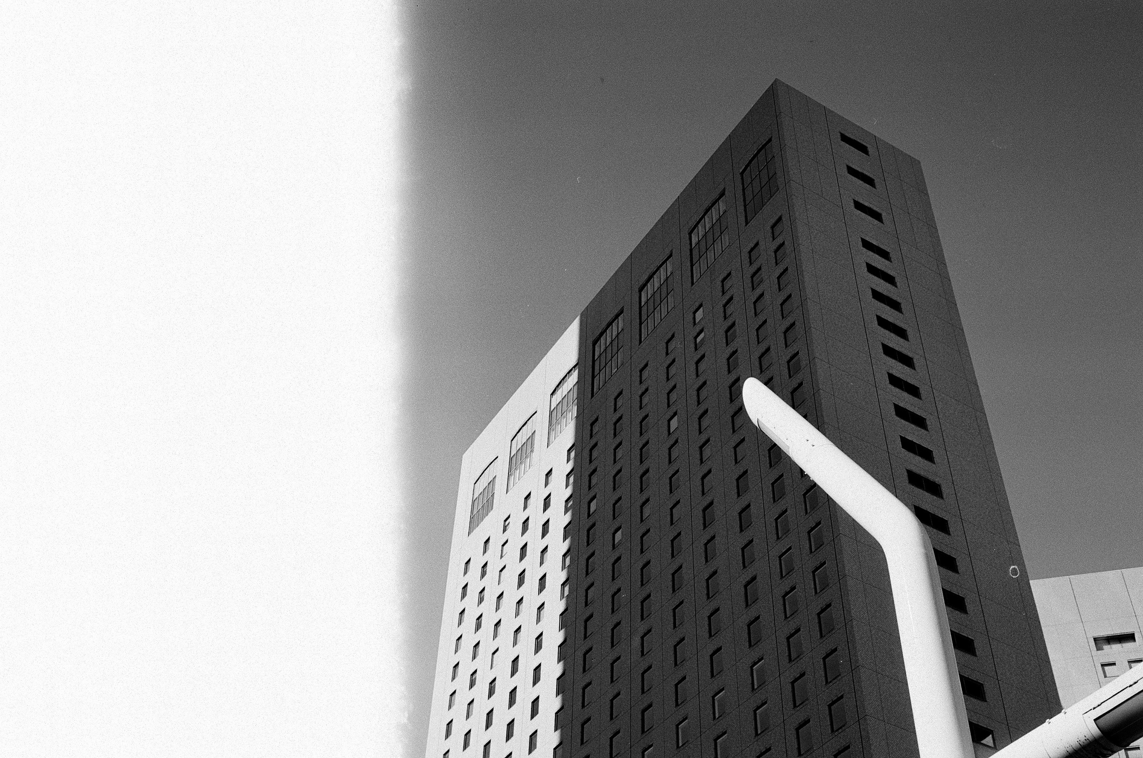 Black and white photograph of a high-rise building showcasing linear design and texture