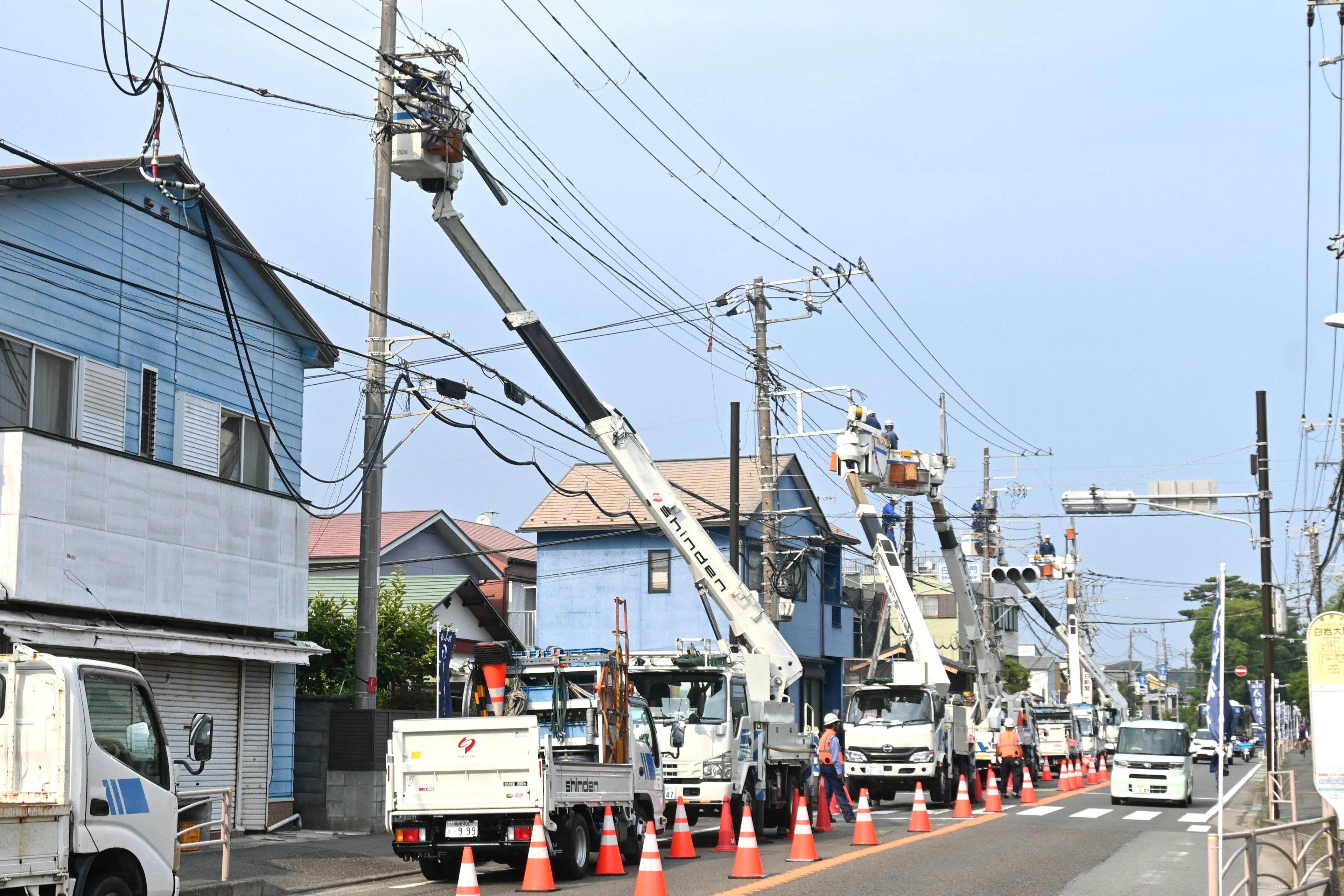 Escena de trabajadores de servicios públicos y camiones en un sitio de reparación de líneas eléctricas