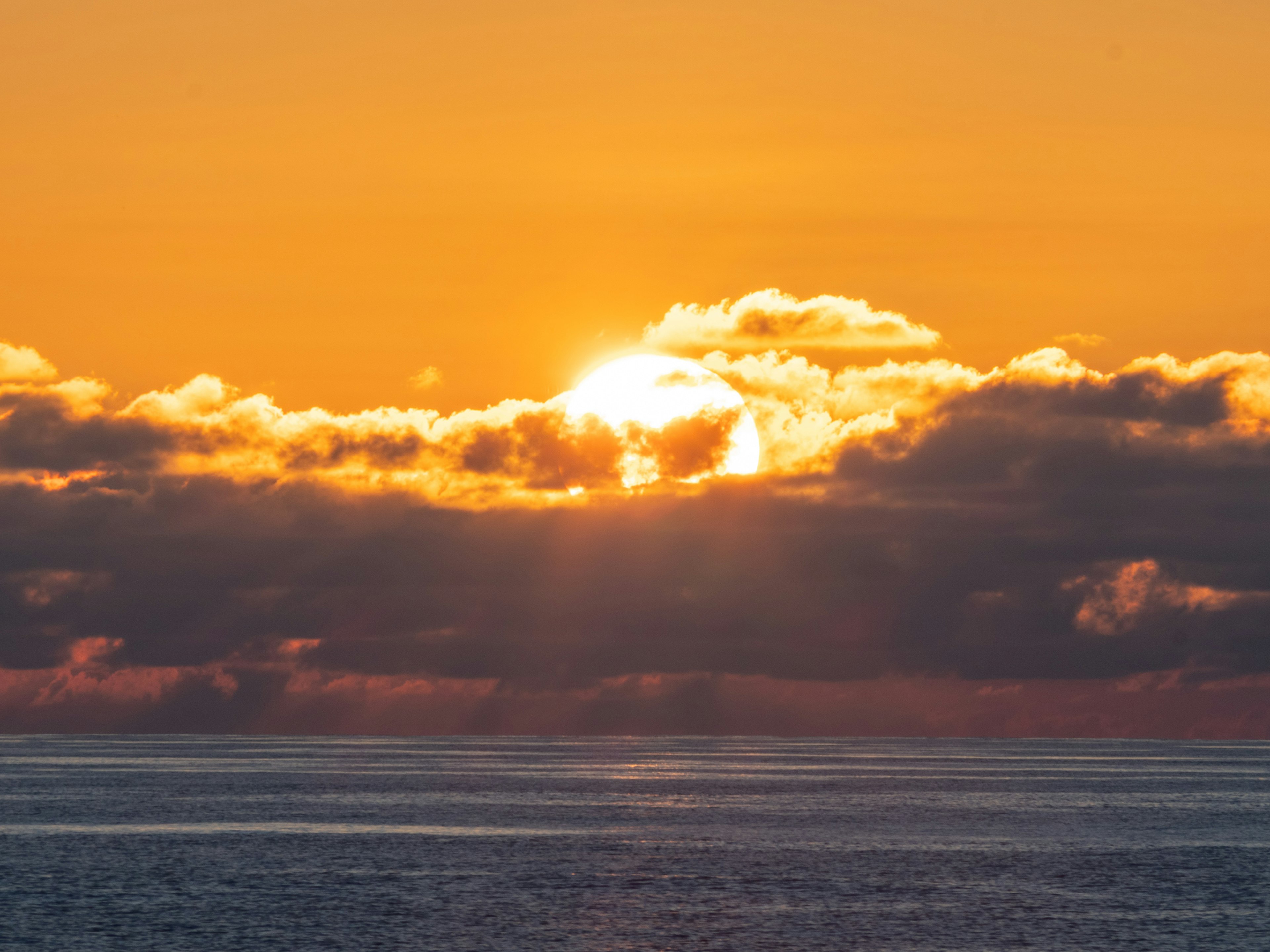 Hermoso paisaje marino con el sol saliendo entre las nubes