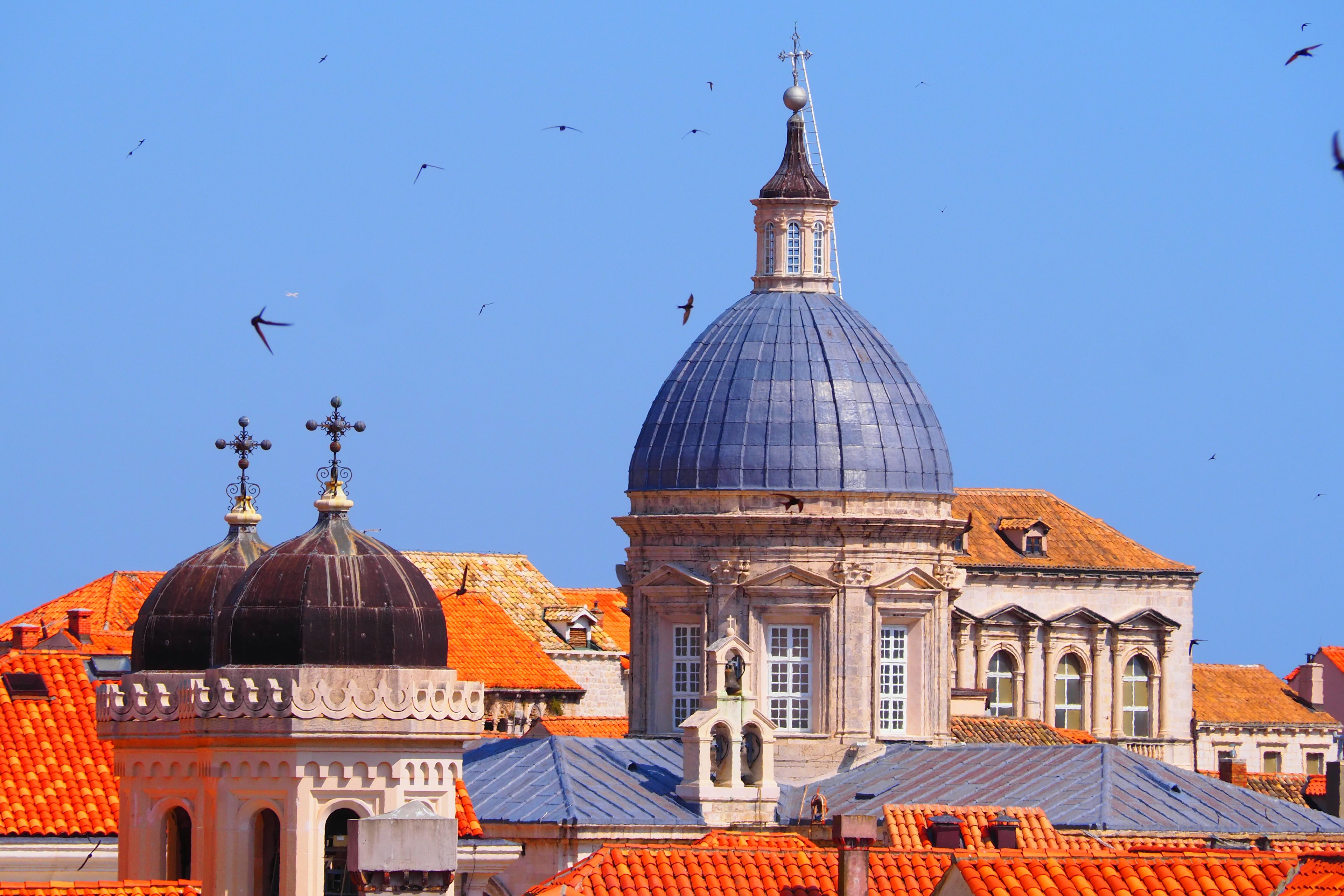 Schöne Kuppelkirche mit Kreuz auf roten Dächern