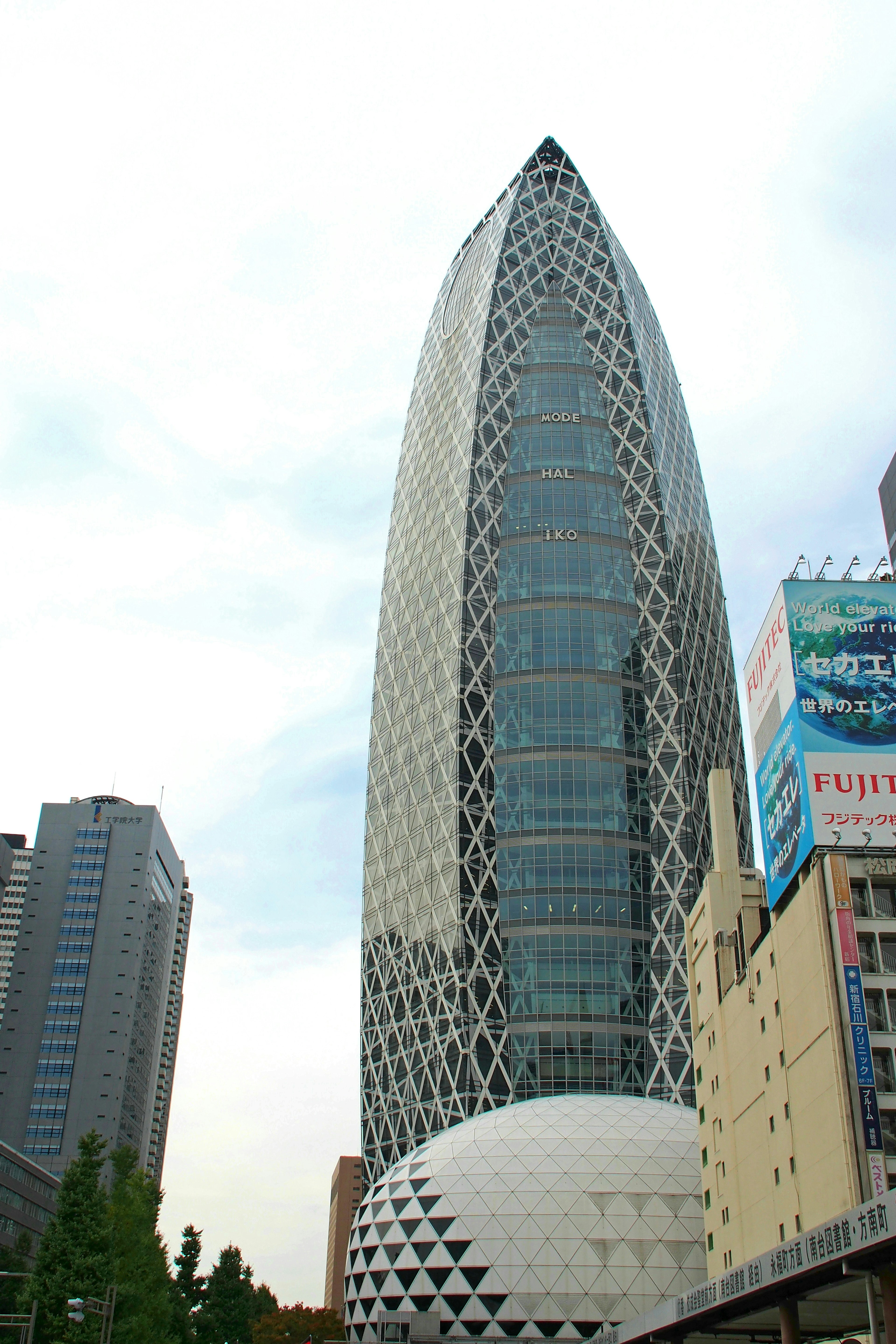 Contrasto tra un edificio a forma di cupola e un grattacielo moderno a Shinjuku