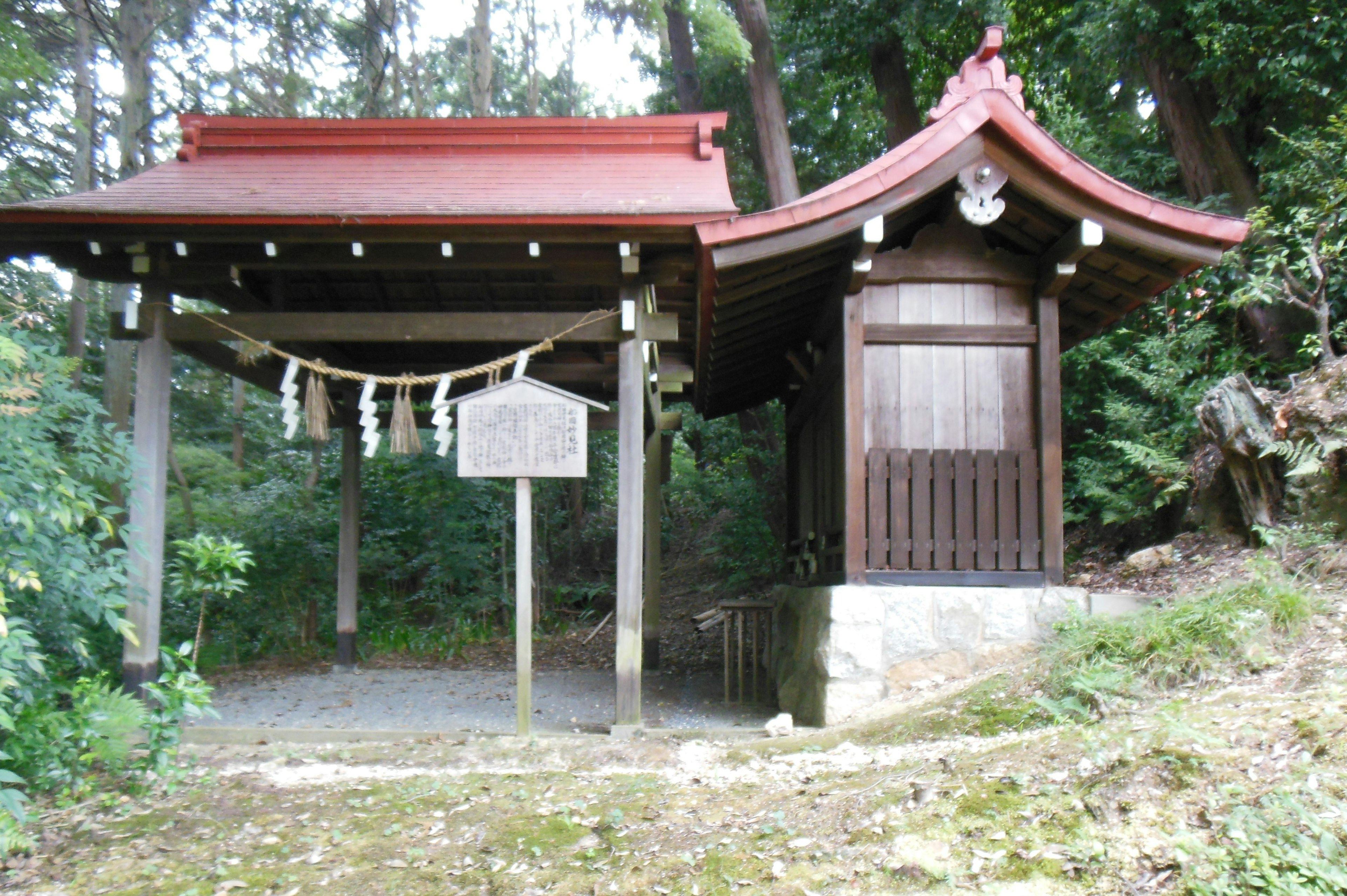 Image of a traditional shrine featuring a red roof and wooden walls