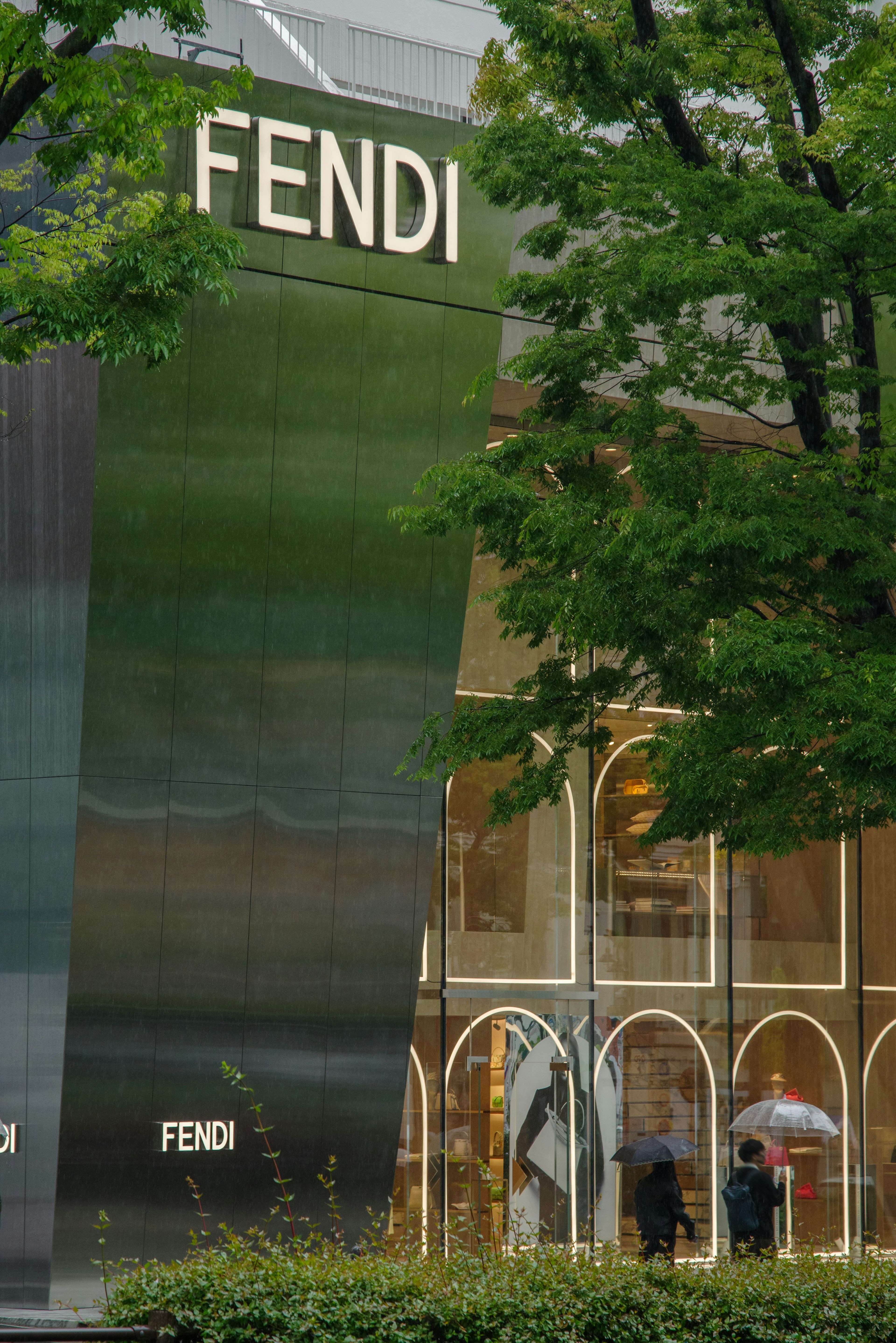 Vue extérieure du magasin de luxe FENDI avec des arbres verts