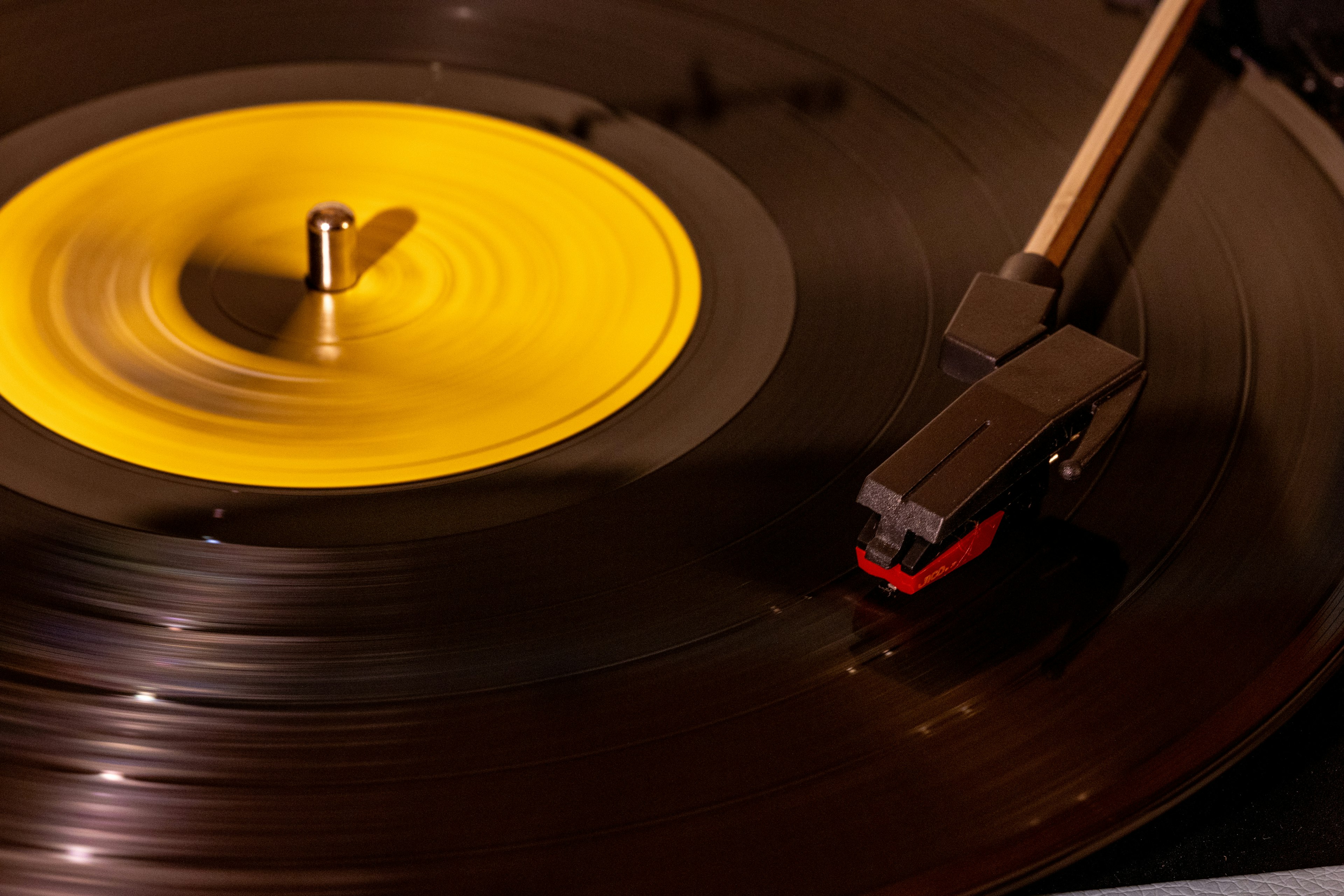 Disco de vinilo amarillo en un tocadiscos con stylus