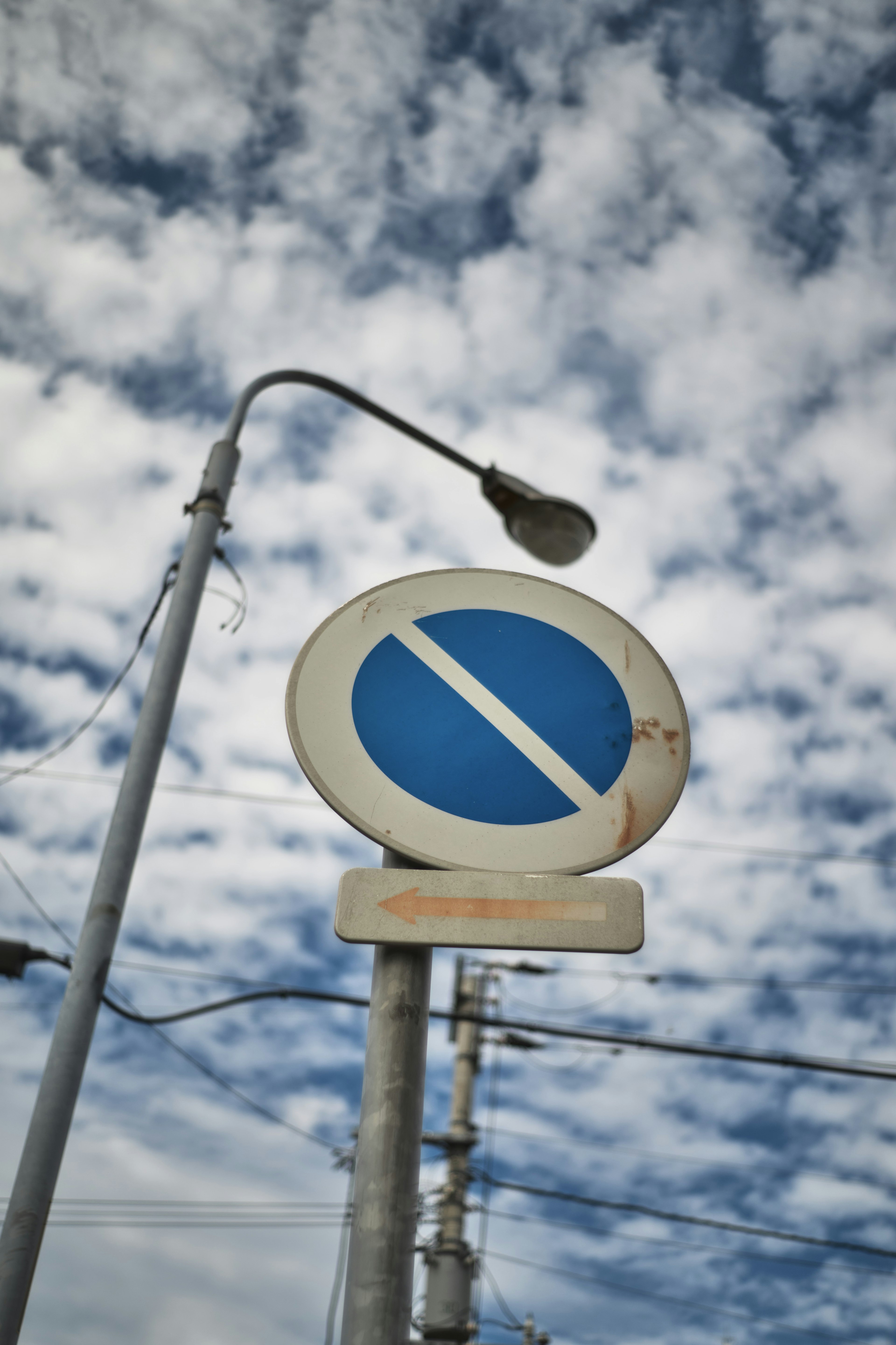 Blaues Verbotsschild vor einem bewölkten Himmel