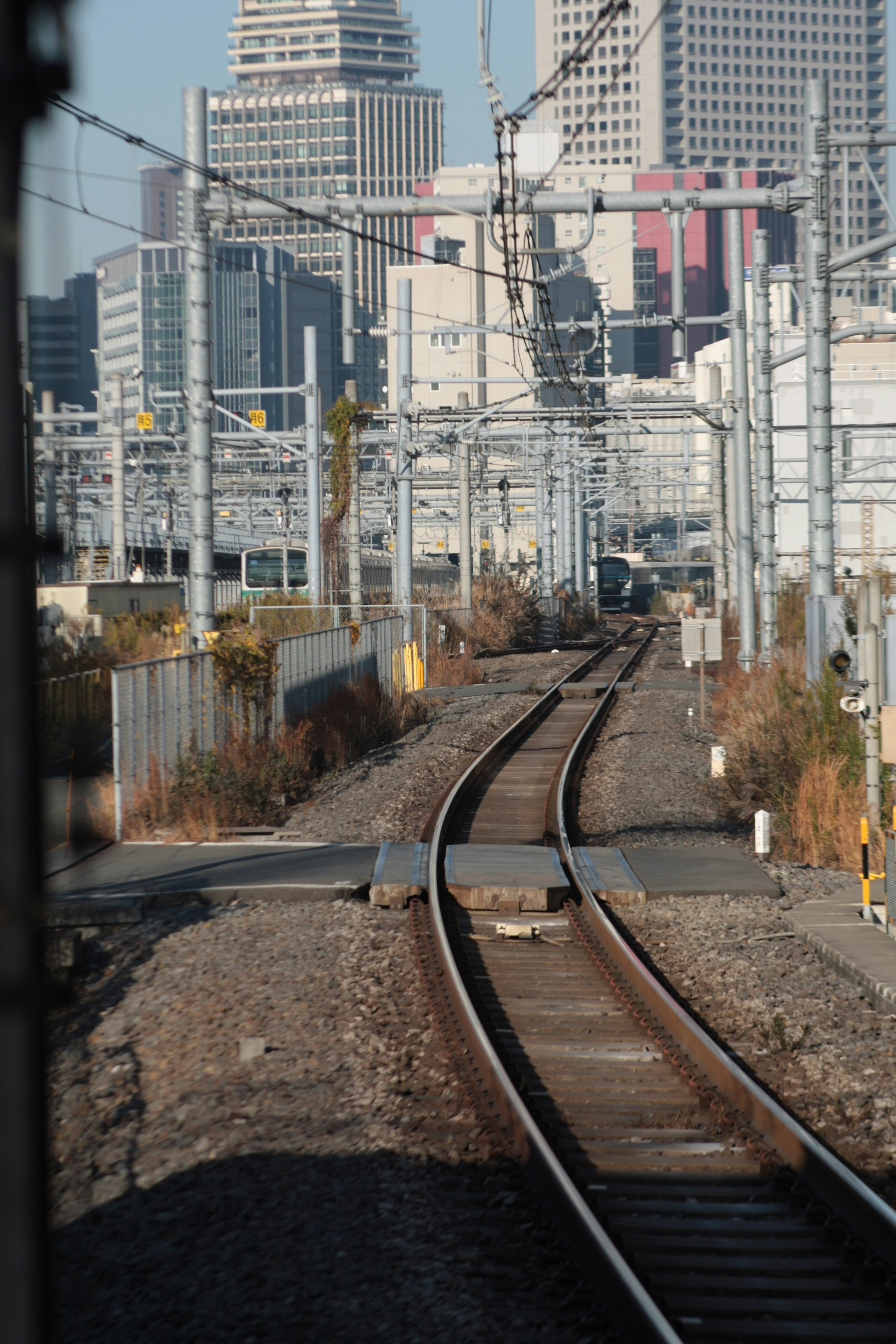 Binari ferroviari che conducono a uno skyline cittadino con grattacieli