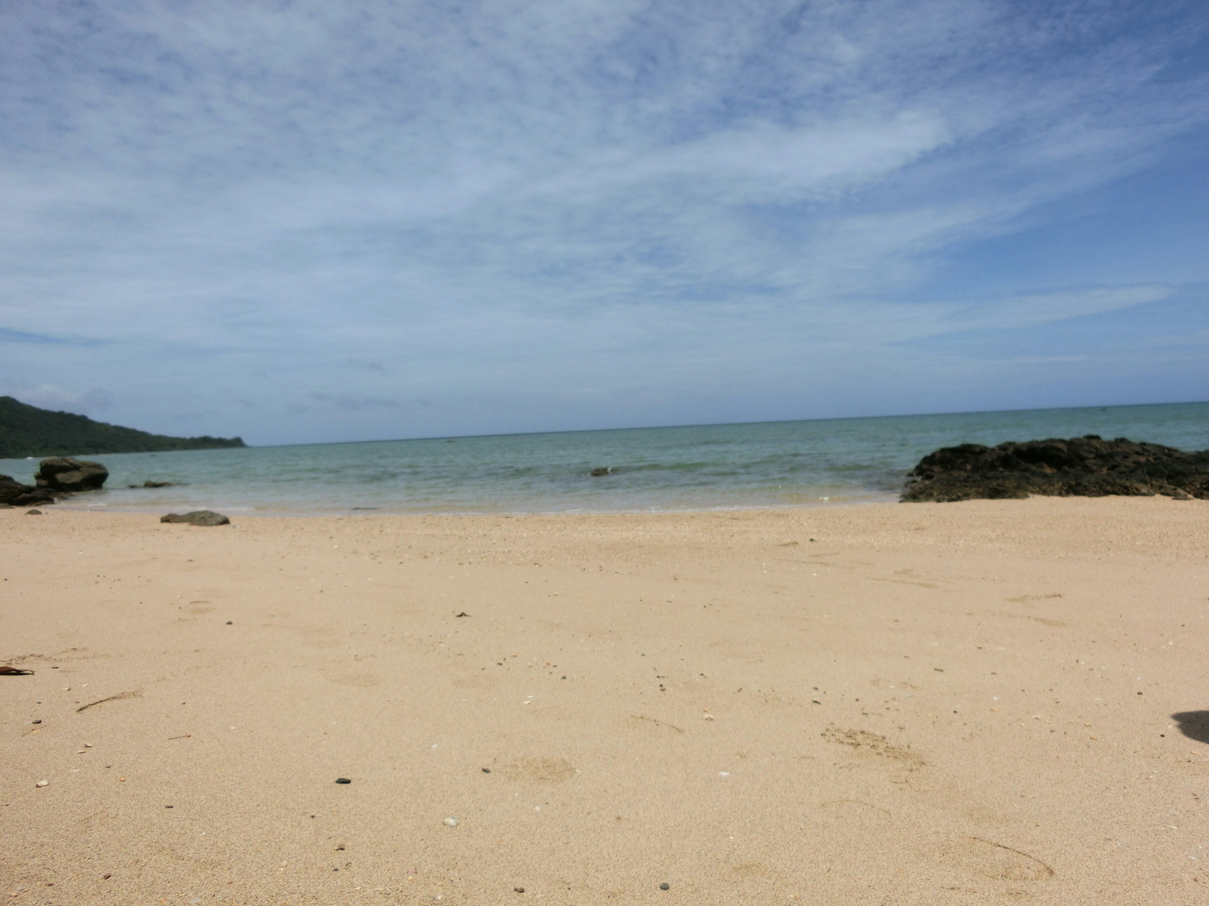 ทิวทัศน์ชายหาดเงียบสงบกับทะเลสงบและท้องฟ้าสีฟ้า