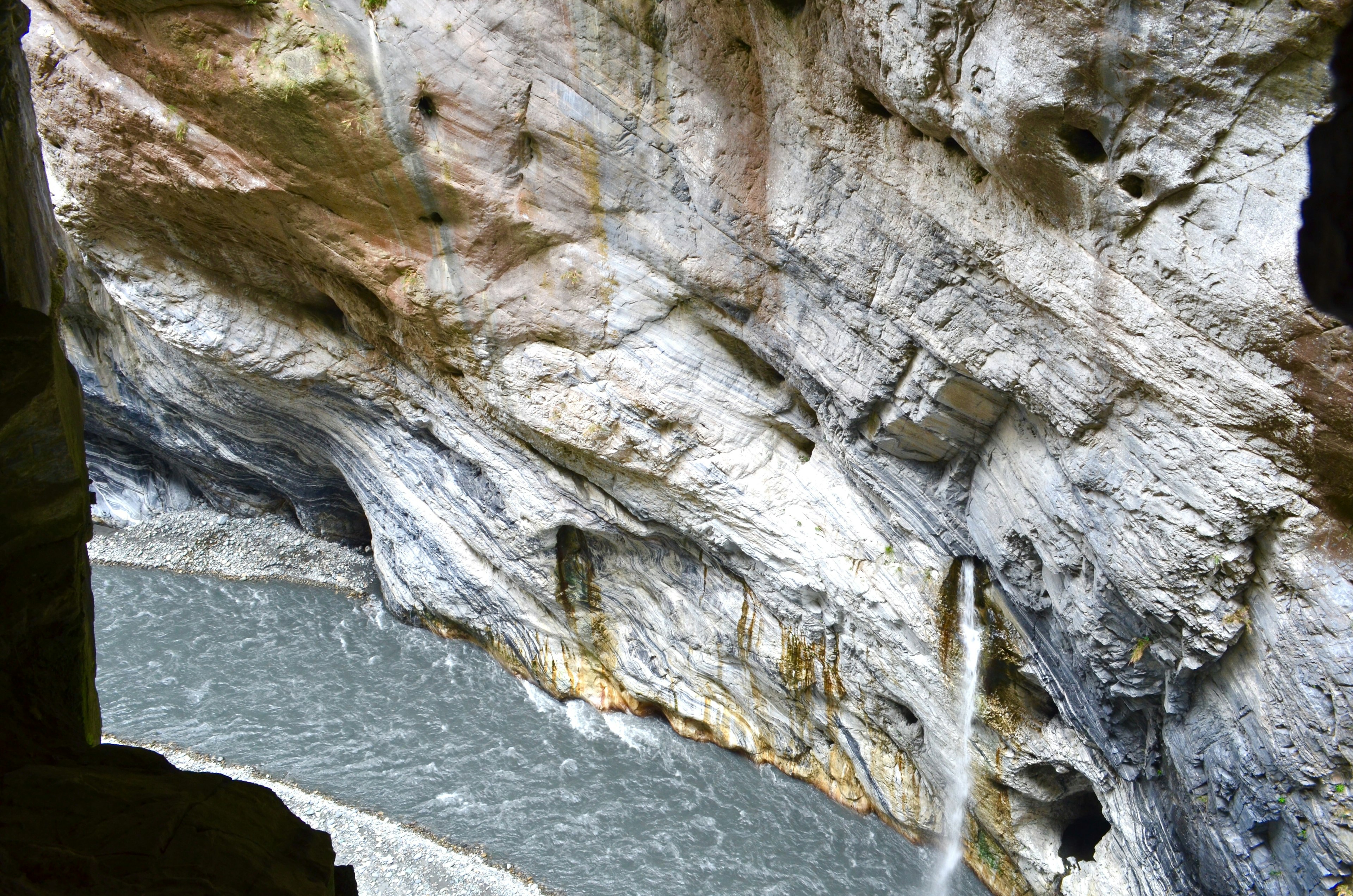 Cascata che scorre su una parete rocciosa con fiume