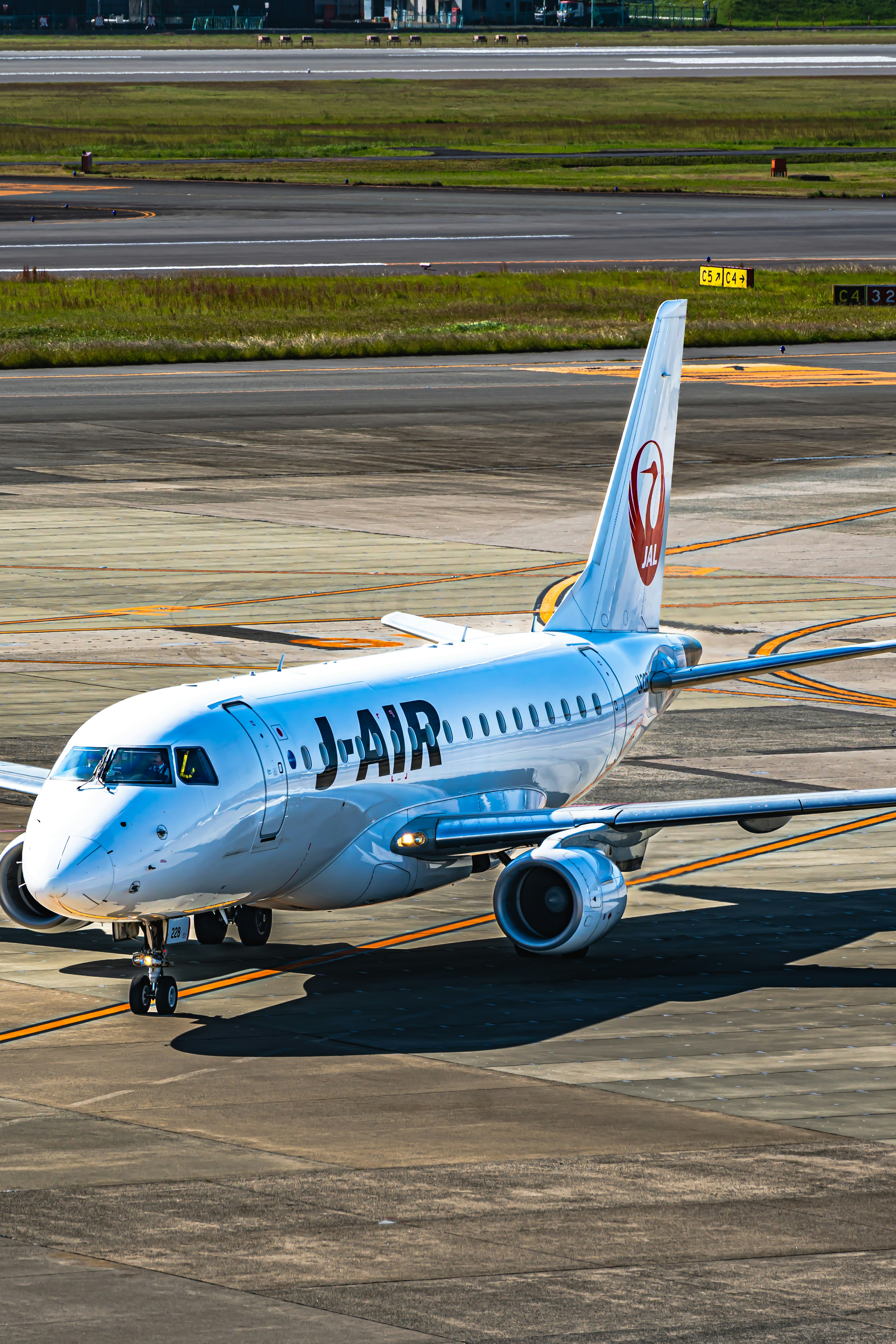 เครื่องบินสีขาวที่มีโลโก้ J- AIR บนรันเวย์