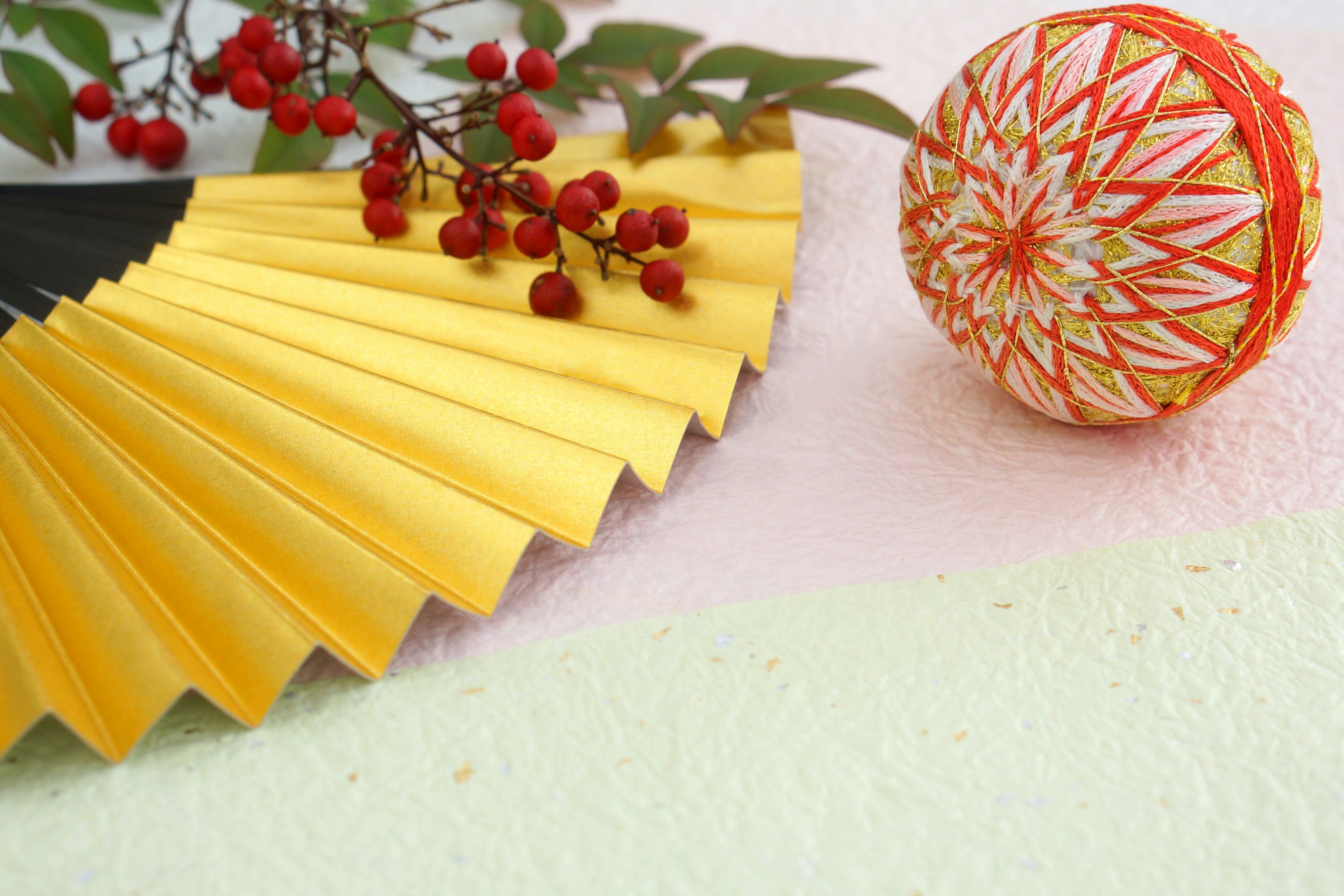 Stillleben mit gelbem Fächer roten Beeren und dekorativem Ball