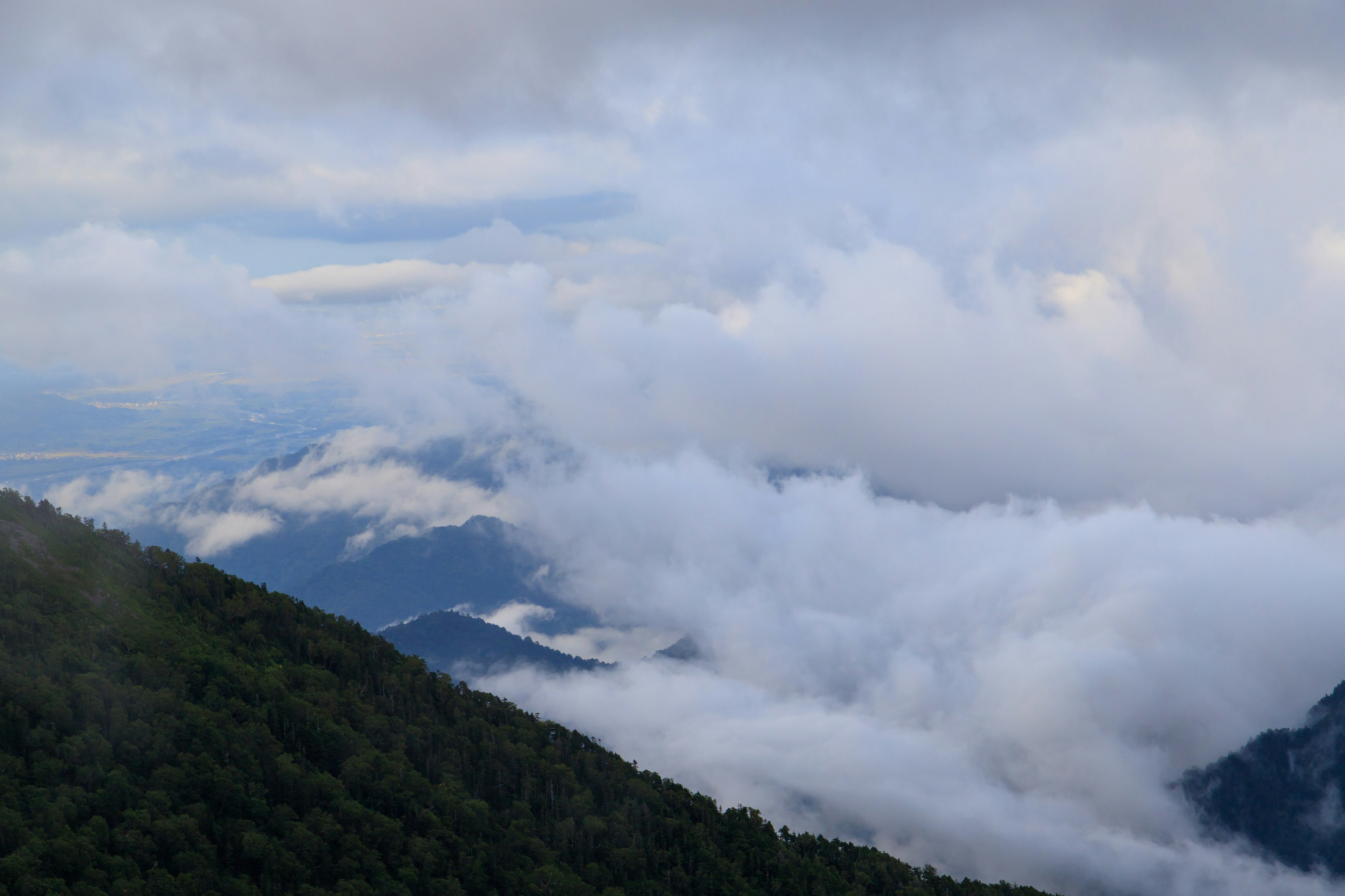 Paisaje montañoso con niebla y cielo azul