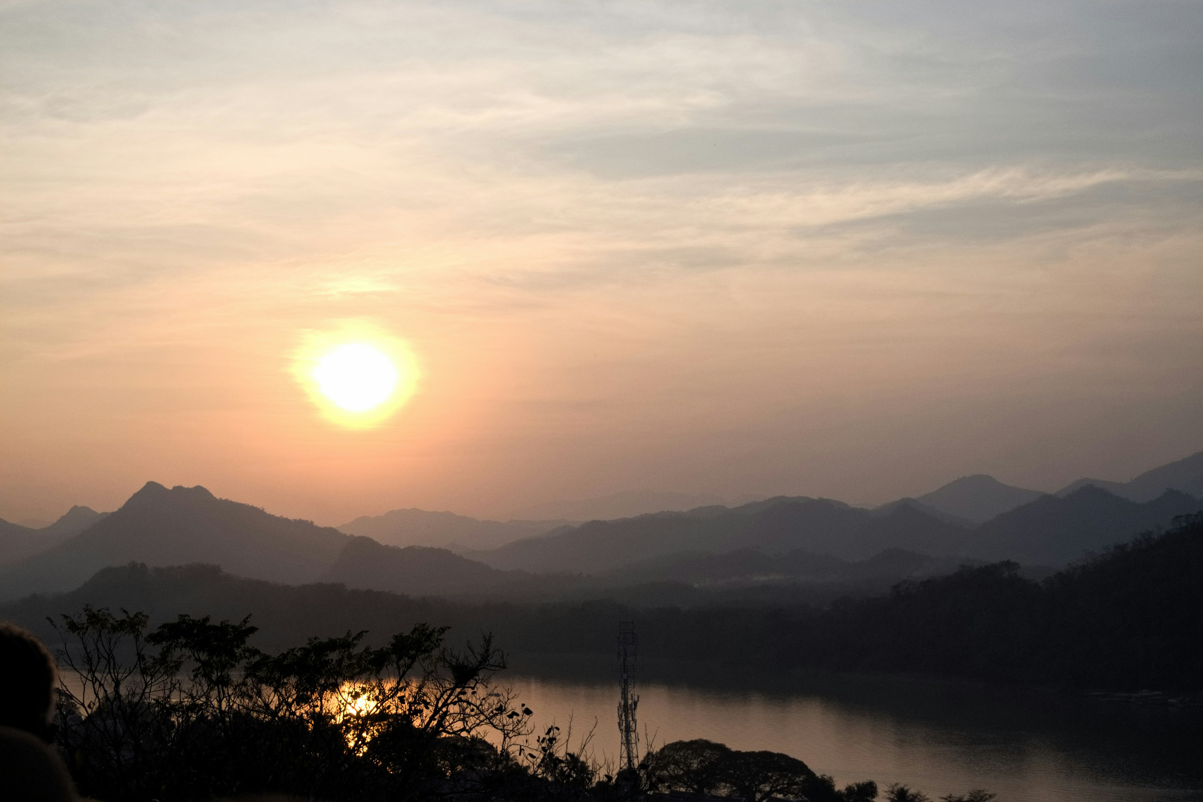 Pemandangan indah dengan matahari terbenam di antara pegunungan