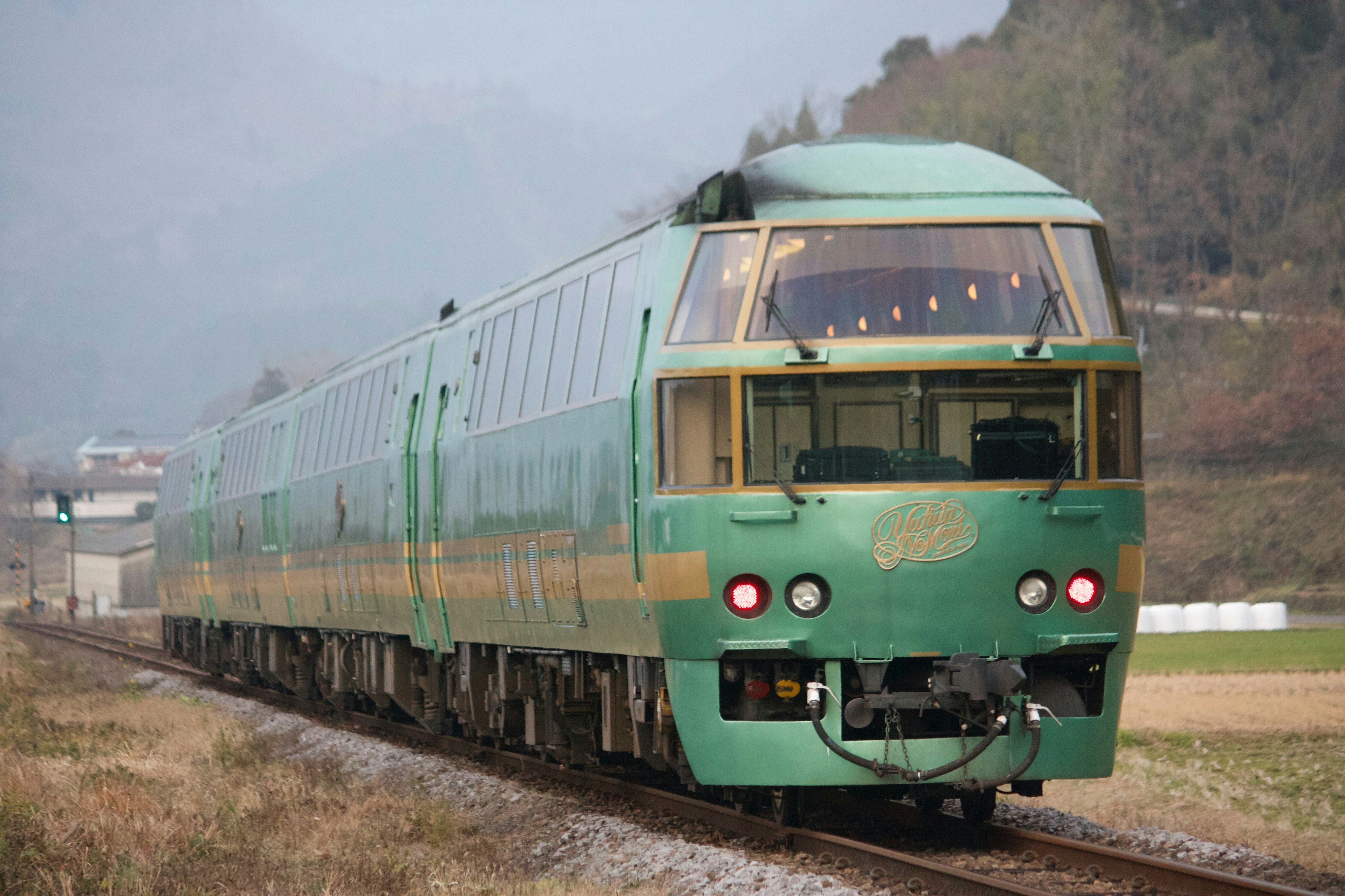 Tren expreso verde que viaja a través de un paisaje pintoresco