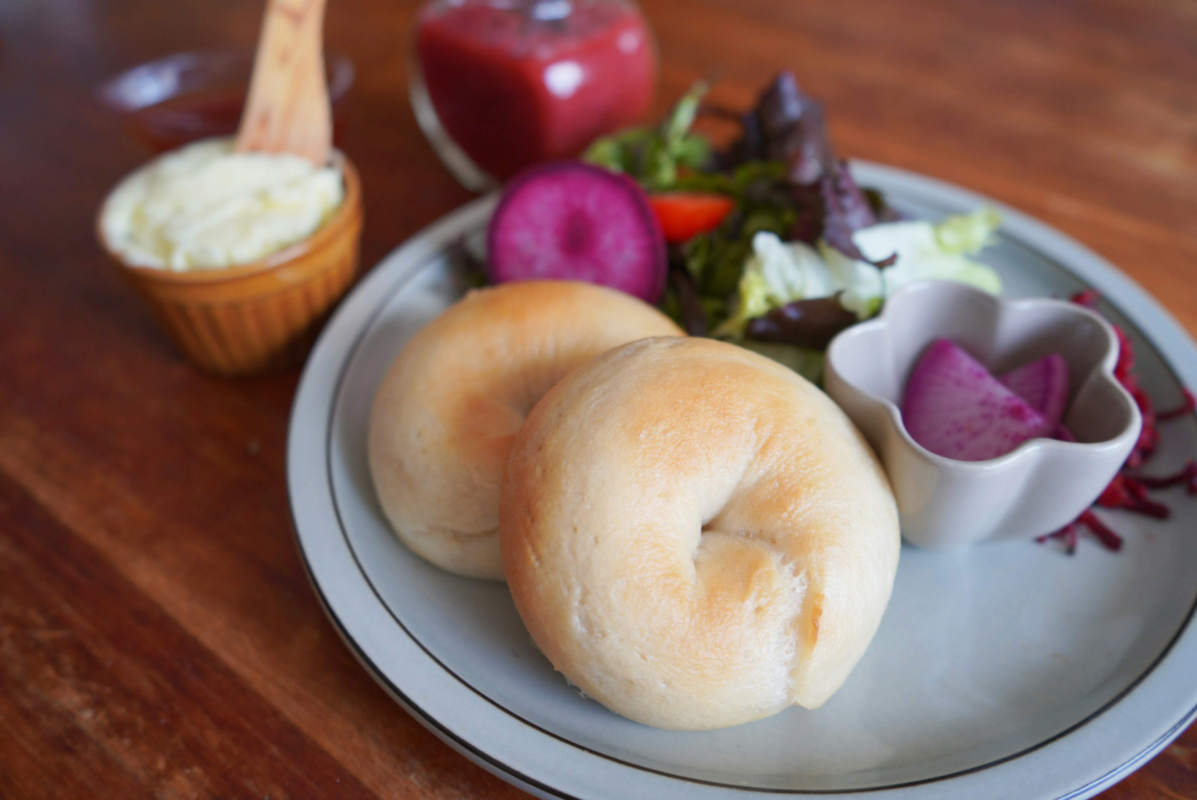 Bagels tostados servidos con ensalada, fruta y una salsa para mojar