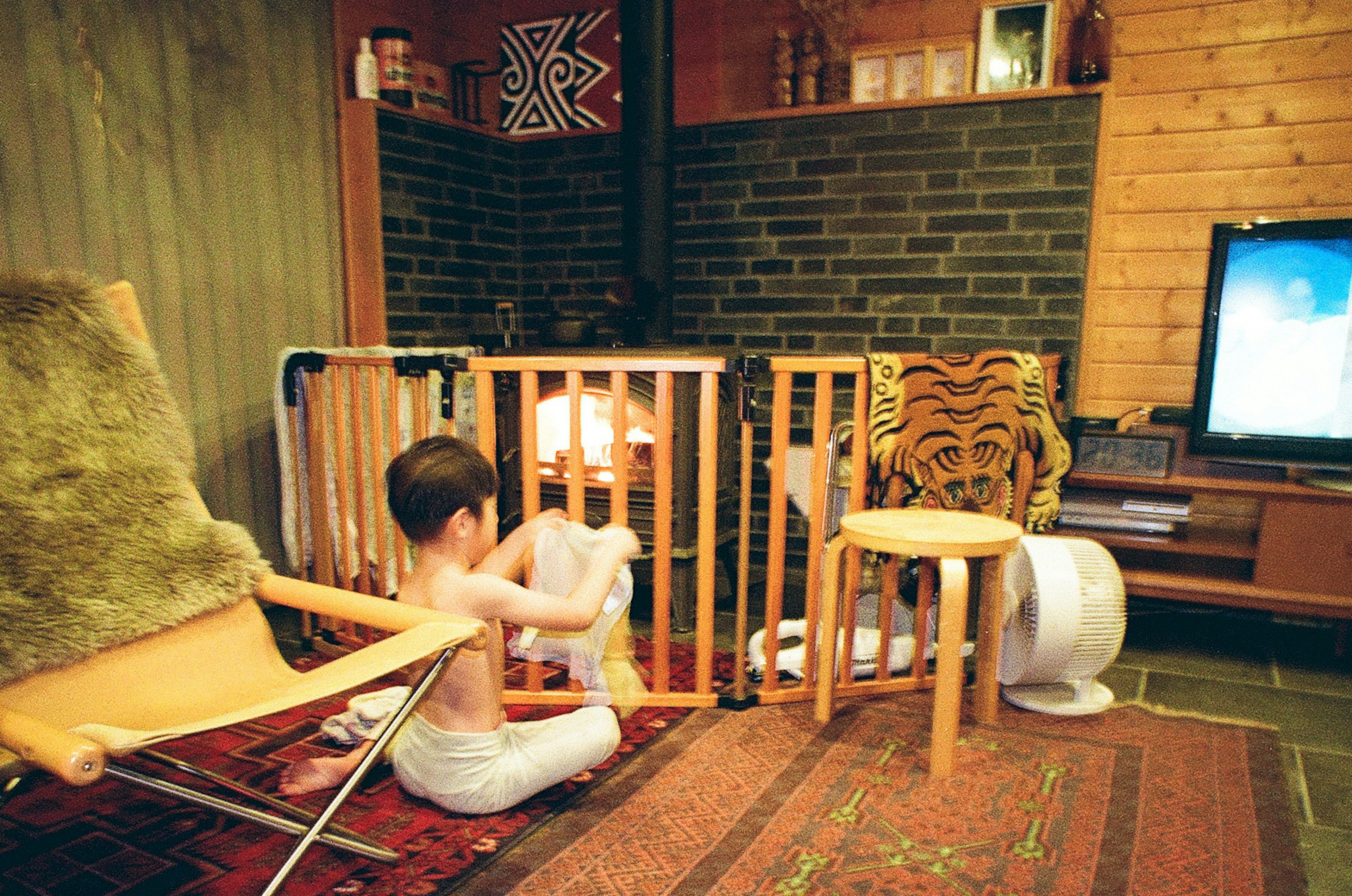 子供が暖炉の前で遊んでいる居間の風景