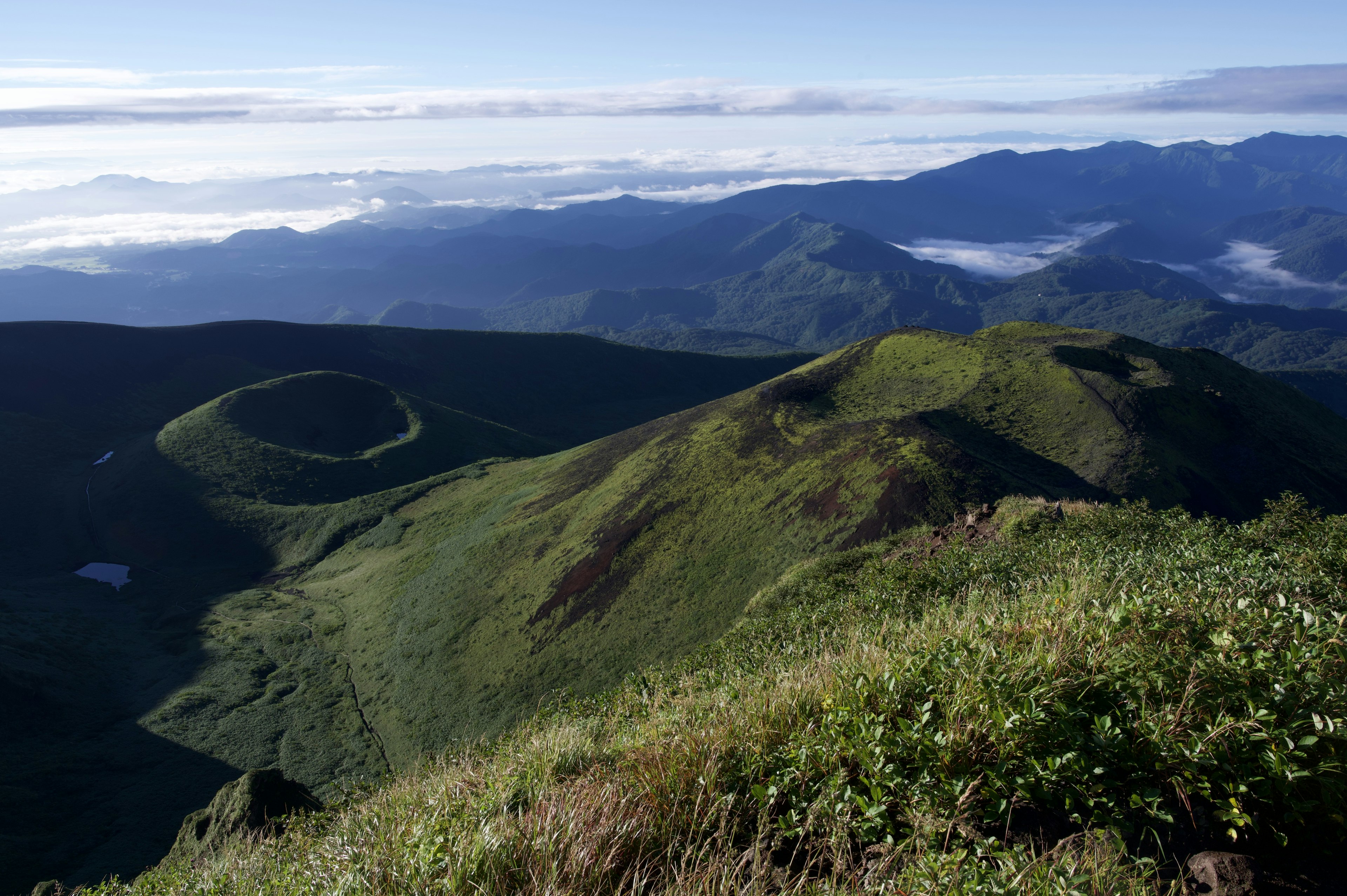 Weitblick auf grüne Berge und ein Wolkenmeer