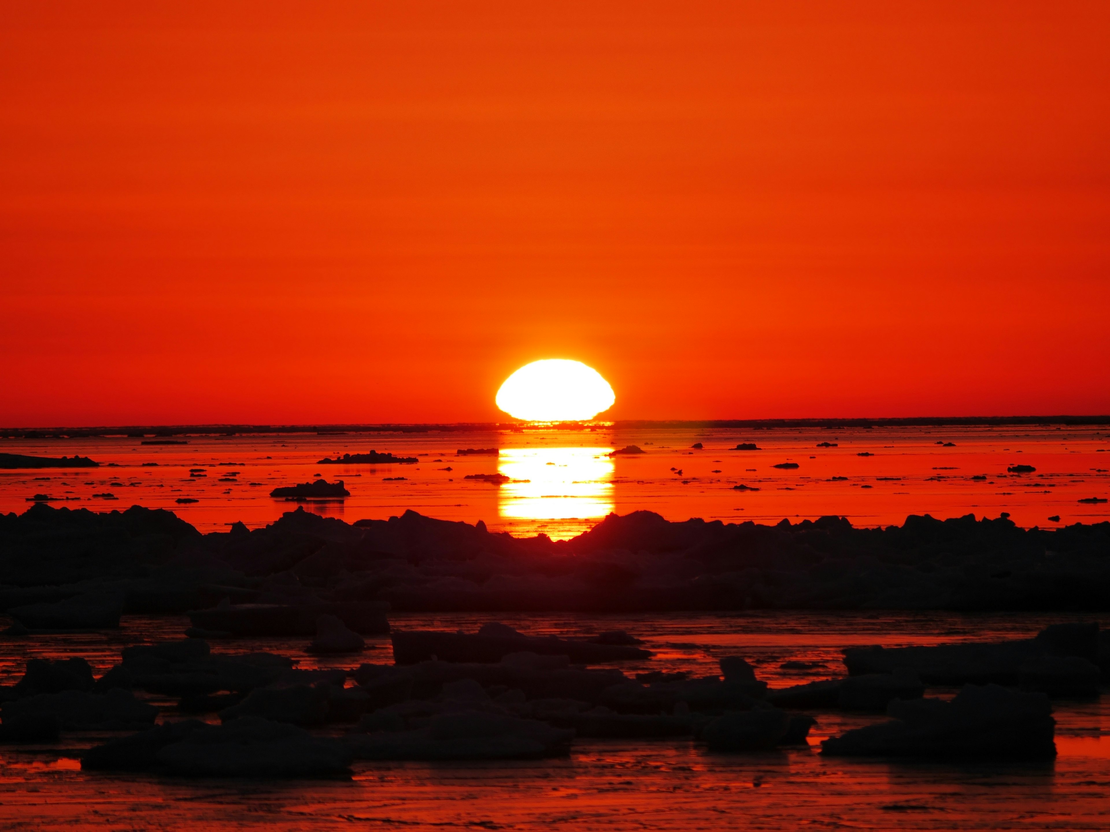 オレンジ色の夕日が海面に反射している美しい風景