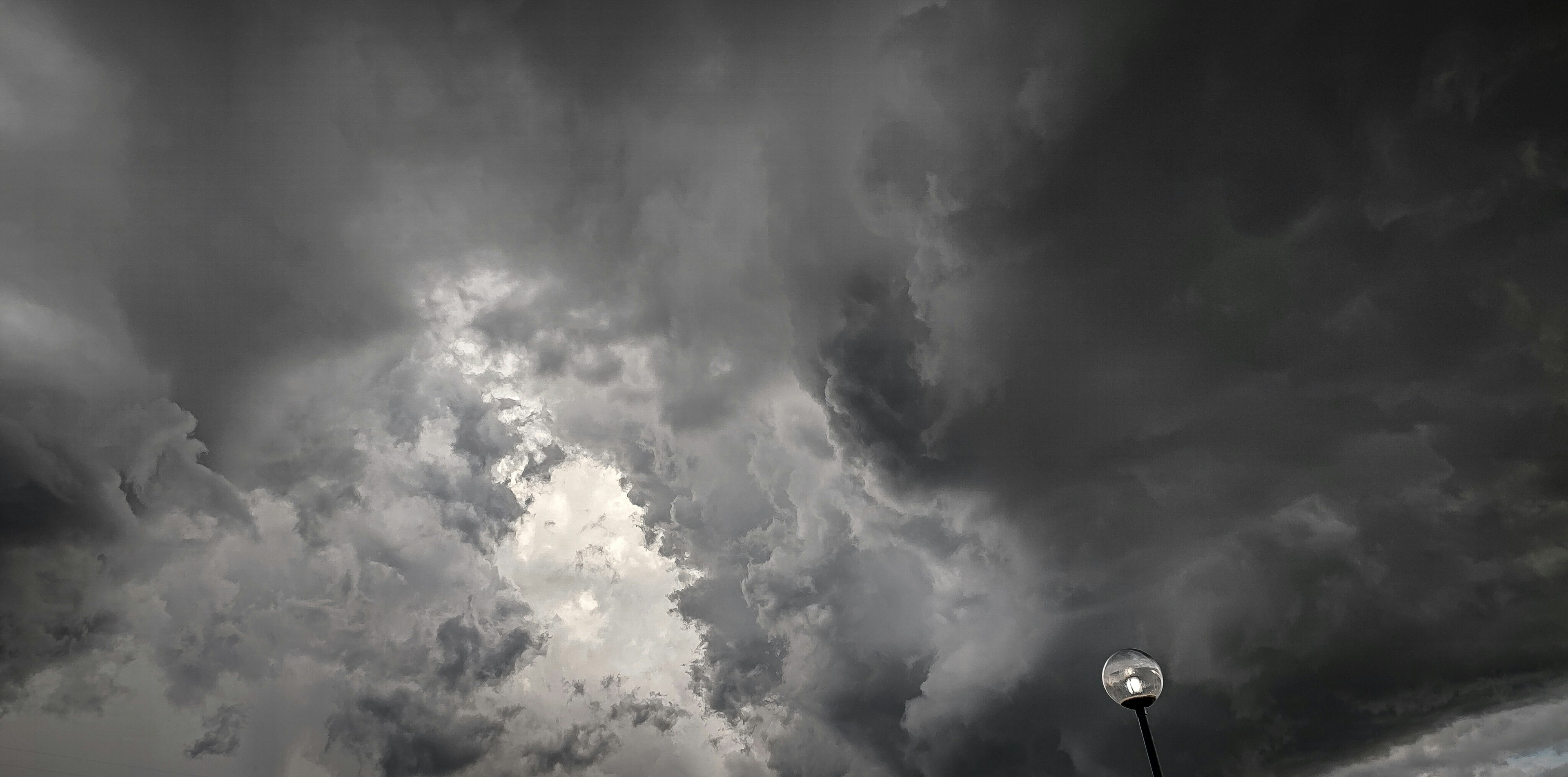 Cielo tormentoso oscuro con nubes en remolino y una nube blanca brillante