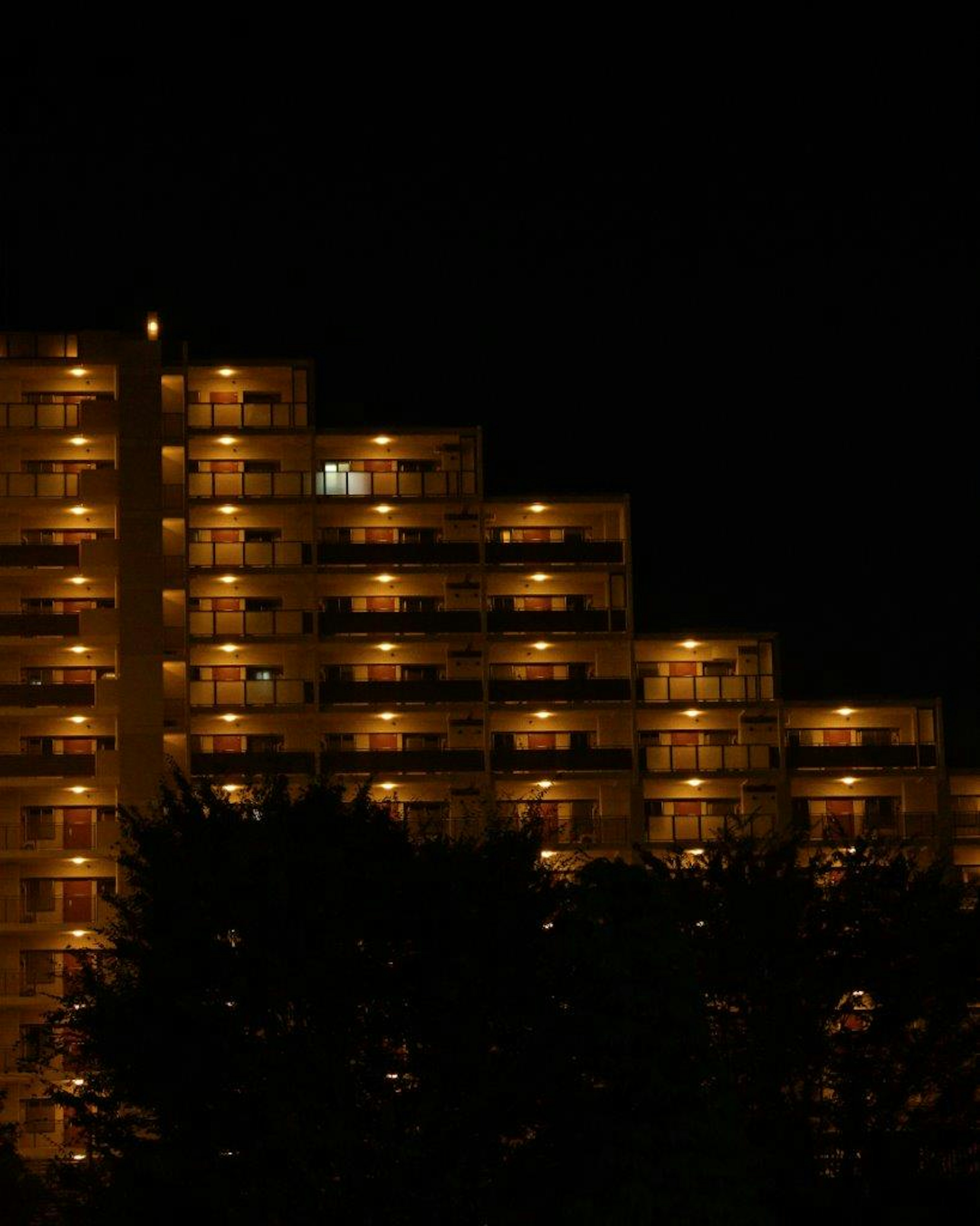 夜の明かりが灯る高層マンションの外観