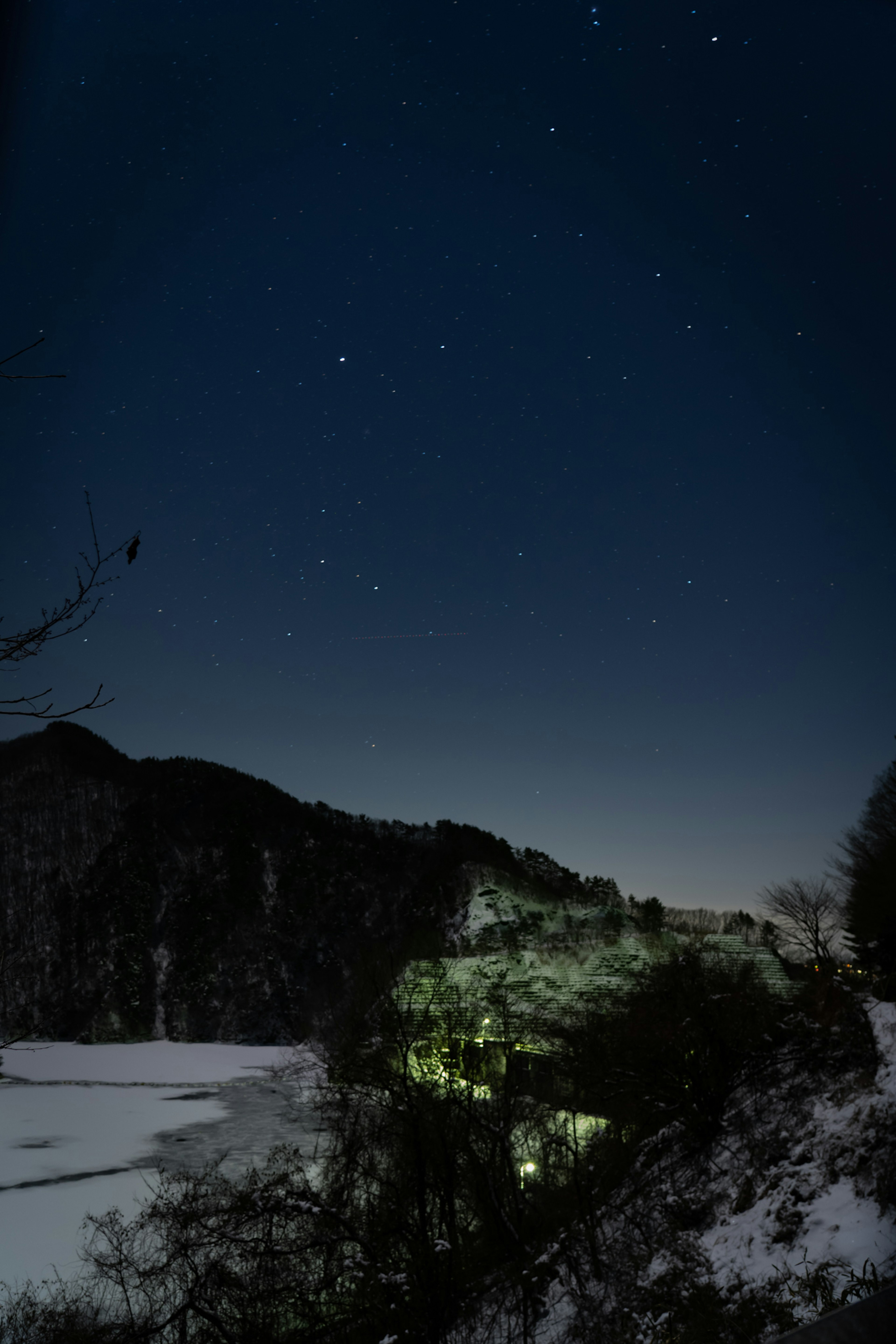 夜空に輝く星々と雪に覆われた湖の風景