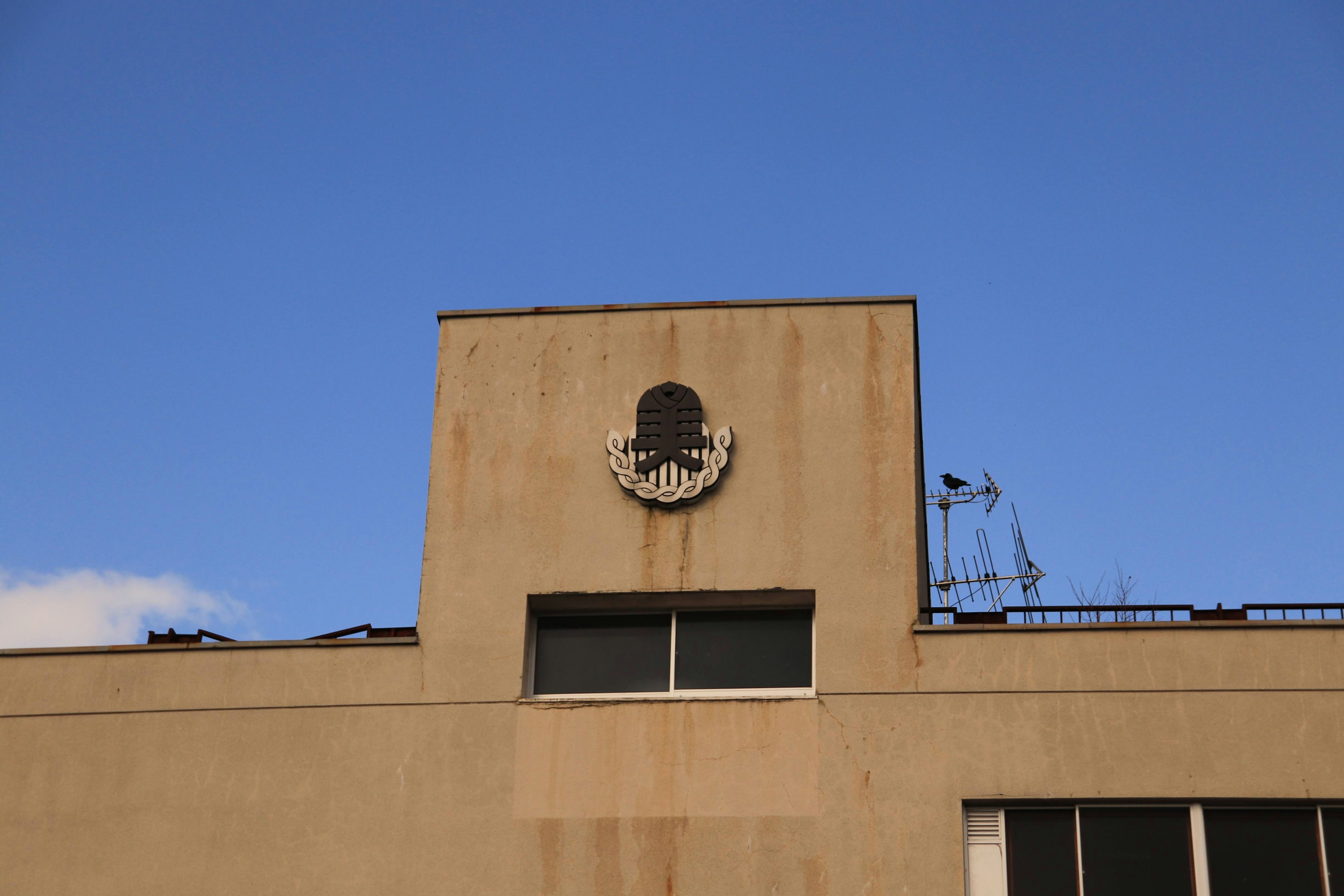 Symbolisches Emblem auf einem Gebäude mit klarem blauen Himmel