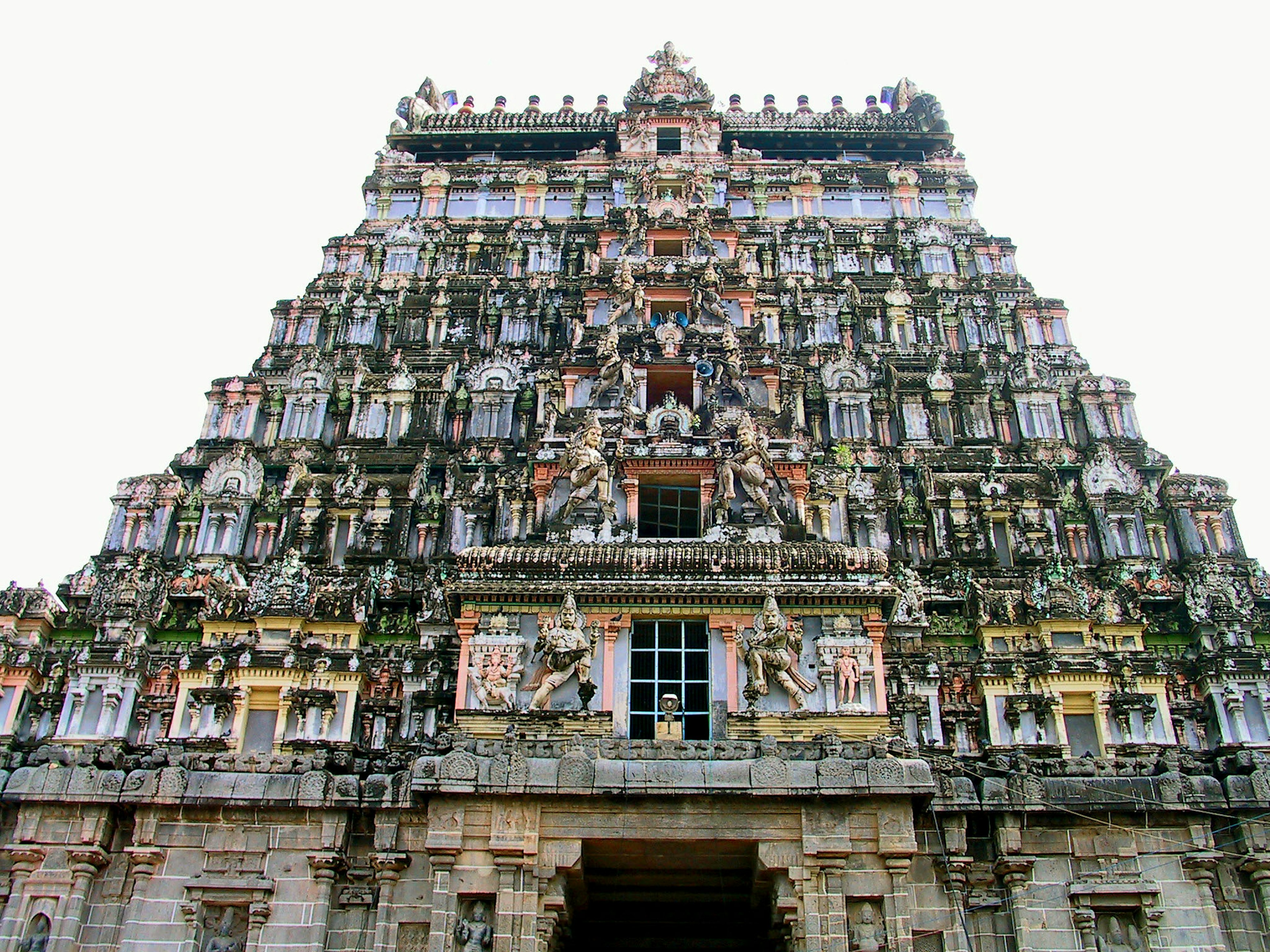 Grand facade of a South Indian temple tower adorned with vibrant sculptures