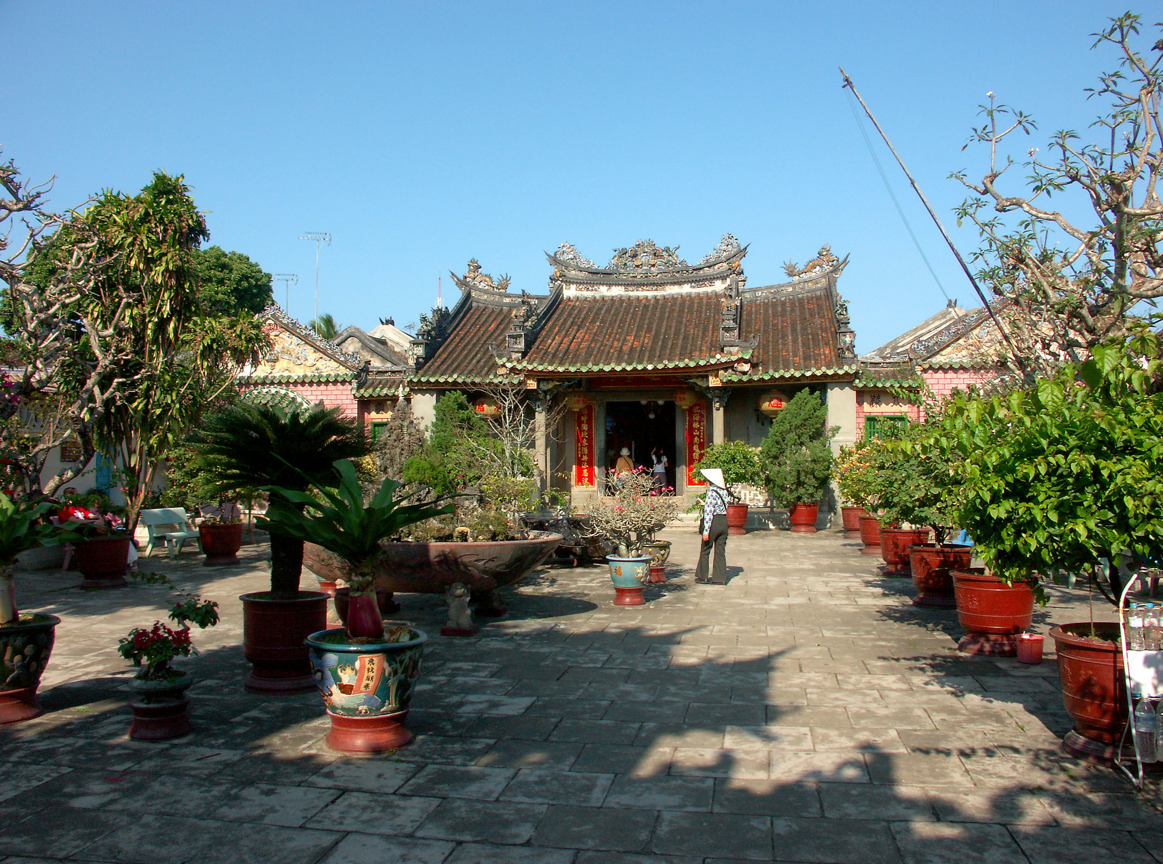 Außenansicht eines Tempels mit üppigem Garten und traditioneller Architektur