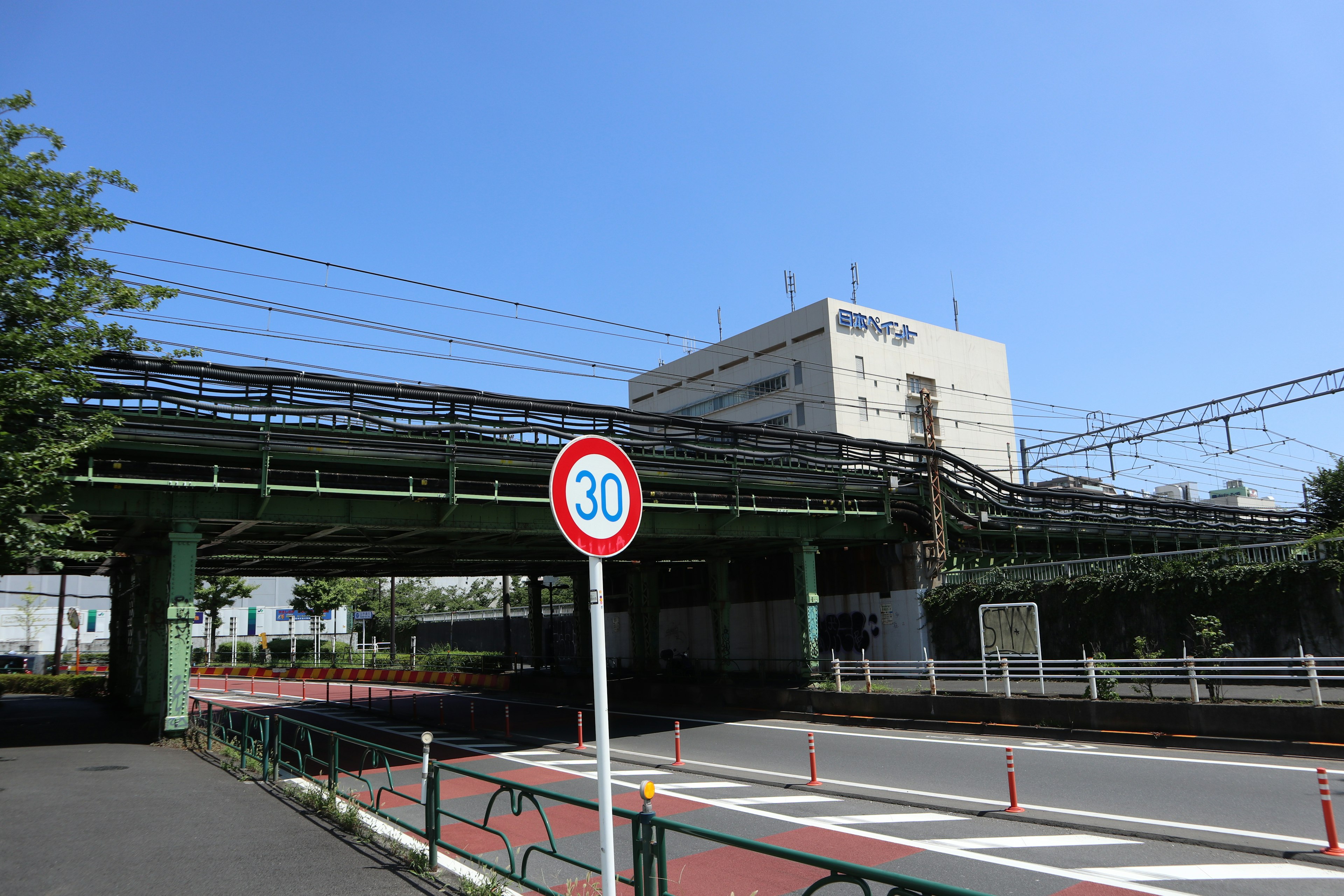 Green railway bridge with a traffic sign in an urban setting